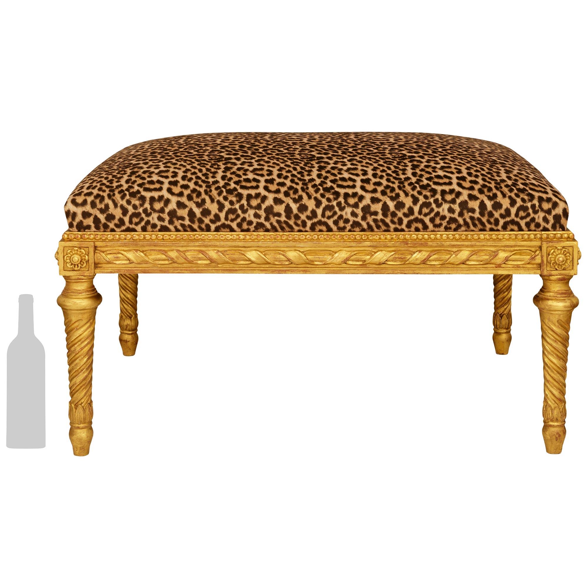 An elegant and high quality French Turn of the Century Louis XVI st. Giltwood bench. This wonderful bench is raised by Giltwood tapered cylindrical legs with spiral fluting leading to rosette blocks at the four corners of the frieze. The frieze