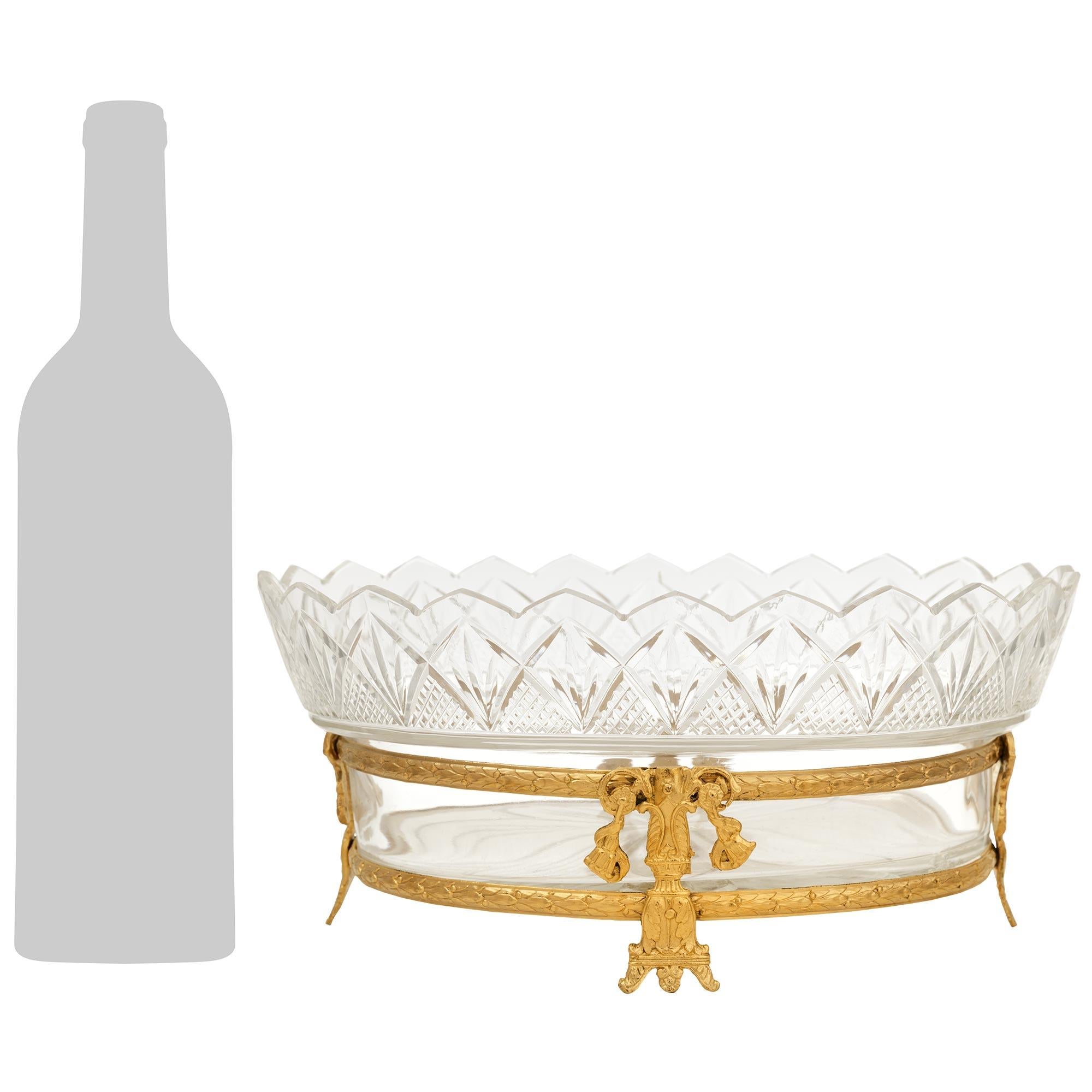 Ein eleganter französischer Tafelaufsatz aus der Jahrhundertwende im Stil Louis XVI, Ormolu und Kristall. Dieser atemberaubende Kristall mit ovalem Schliff wird von doppelten Lorbeerbändern aus Ormolu getragen, die durch vier vertikale Stützen