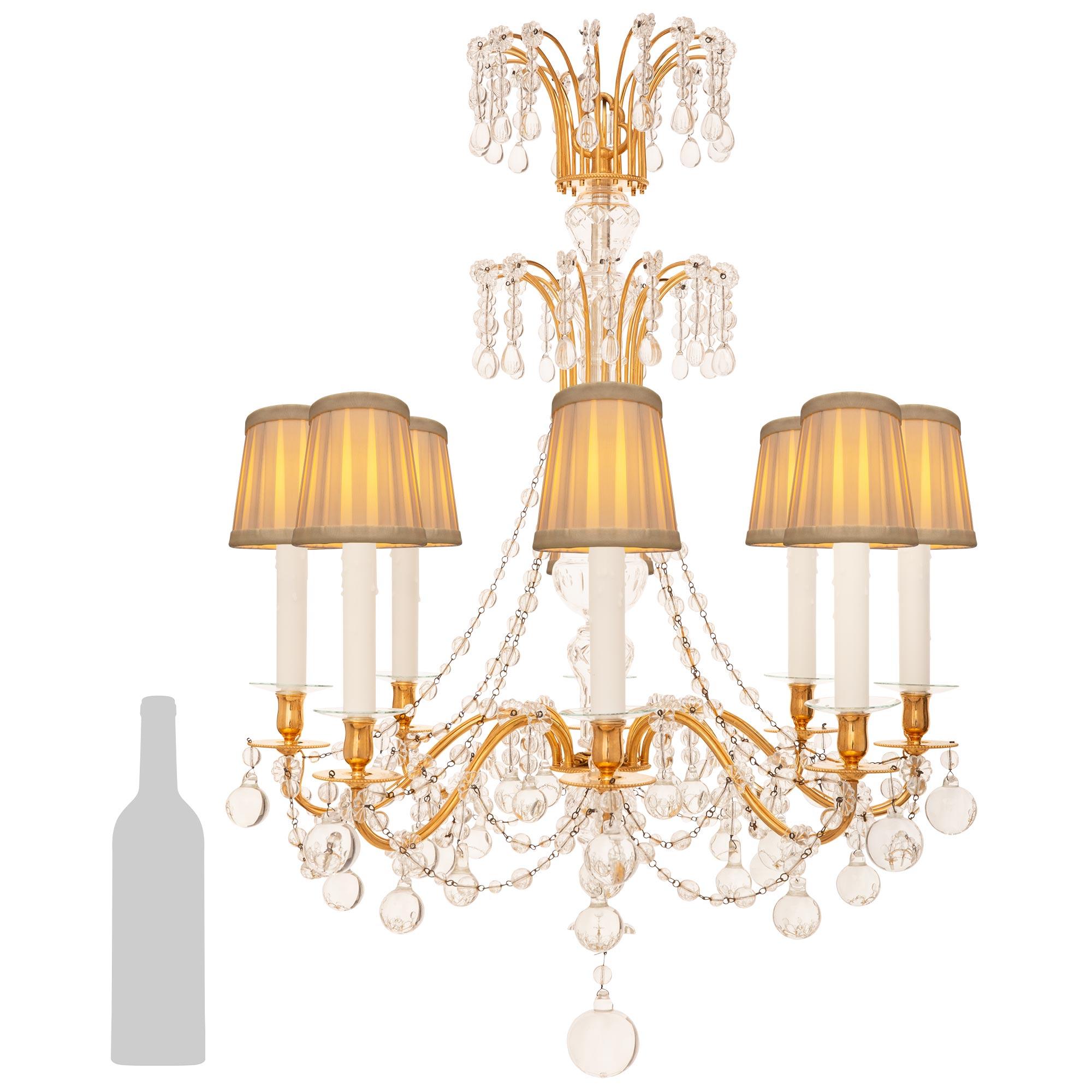 A stunning and high quality French Turn of the Century Louis XVI st. Ormolu and Crystal chandelier. This elegant eight light eight arm chandelier is centered by a bottom Ormolu finial with Crystal spheres and rosettes hanging below. The Crystal
