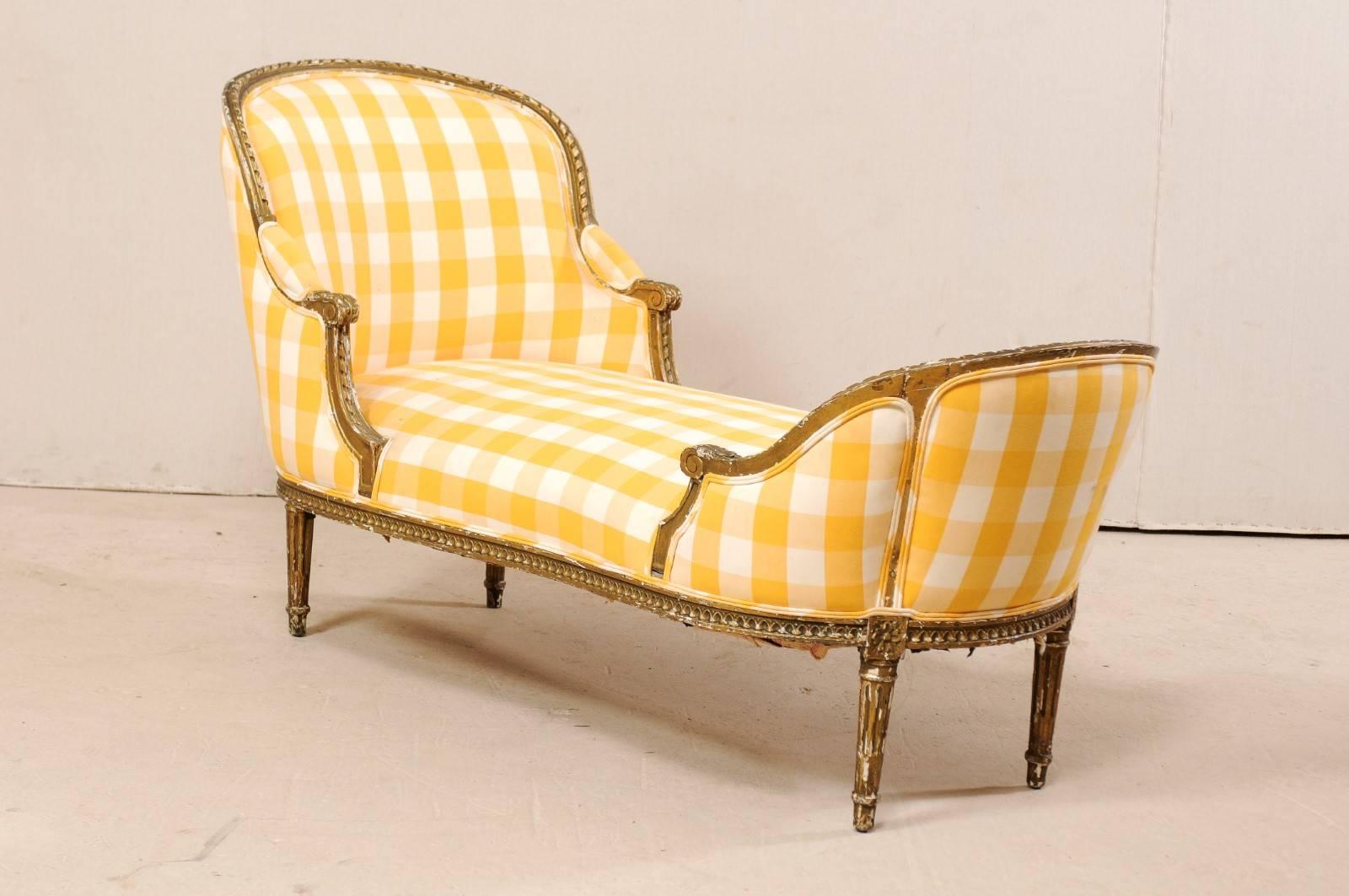 A French Louis XVI style chaise lounge from the turn of the 19th and 20th centuries. This antique Duchesse en Bateau (chaise) from France, in the Louis XVI style, features ribbon and egg-and-dart molding, scrolled knuckles, and rosettes along the