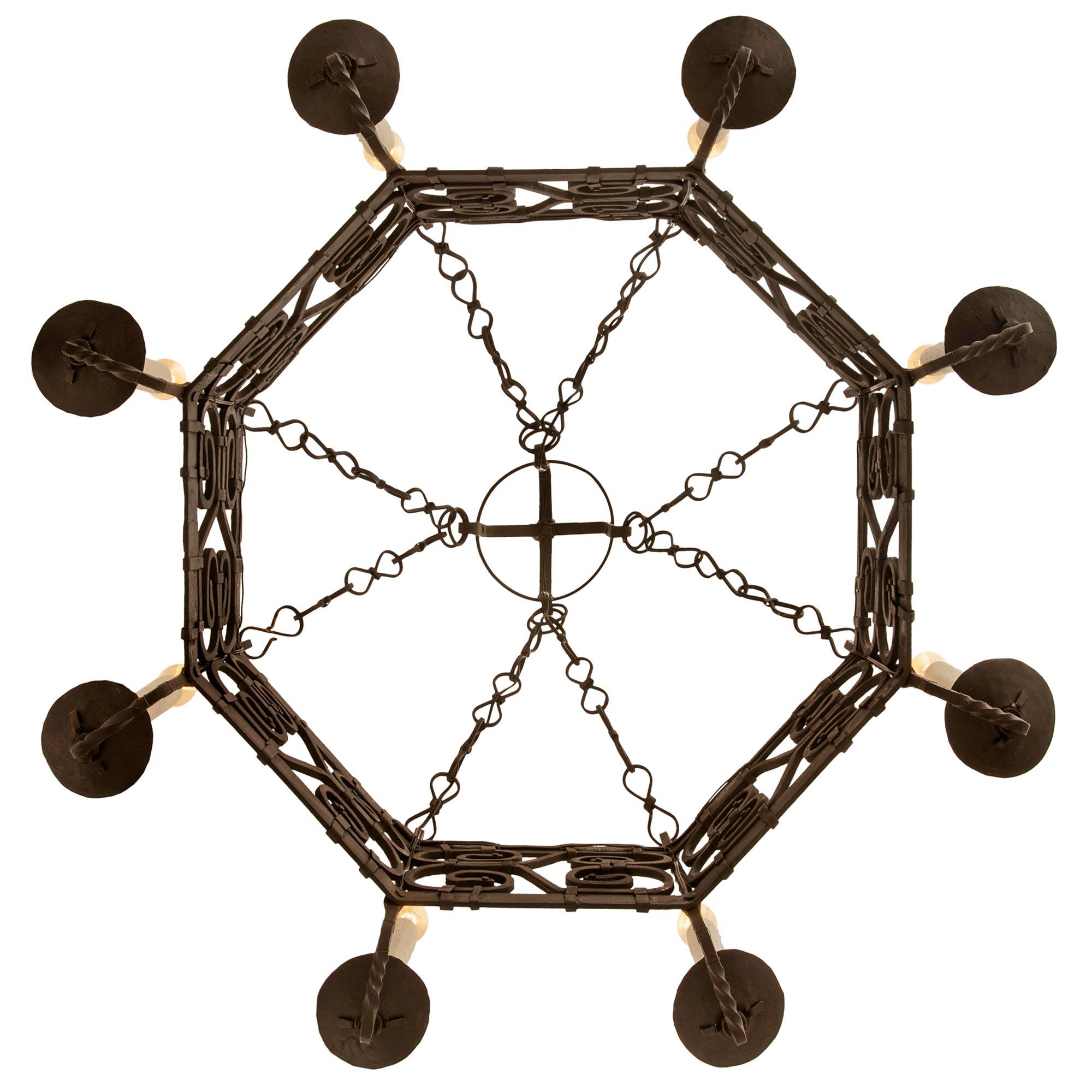 A handsome French Turn of the Century Renaissance st. Wrought Iron chandelier. The eight arm octagonal chandelier consist of a most impressive and detailed mid section displaying wonderful banded scrolls with rosettes and twisted iron bars.