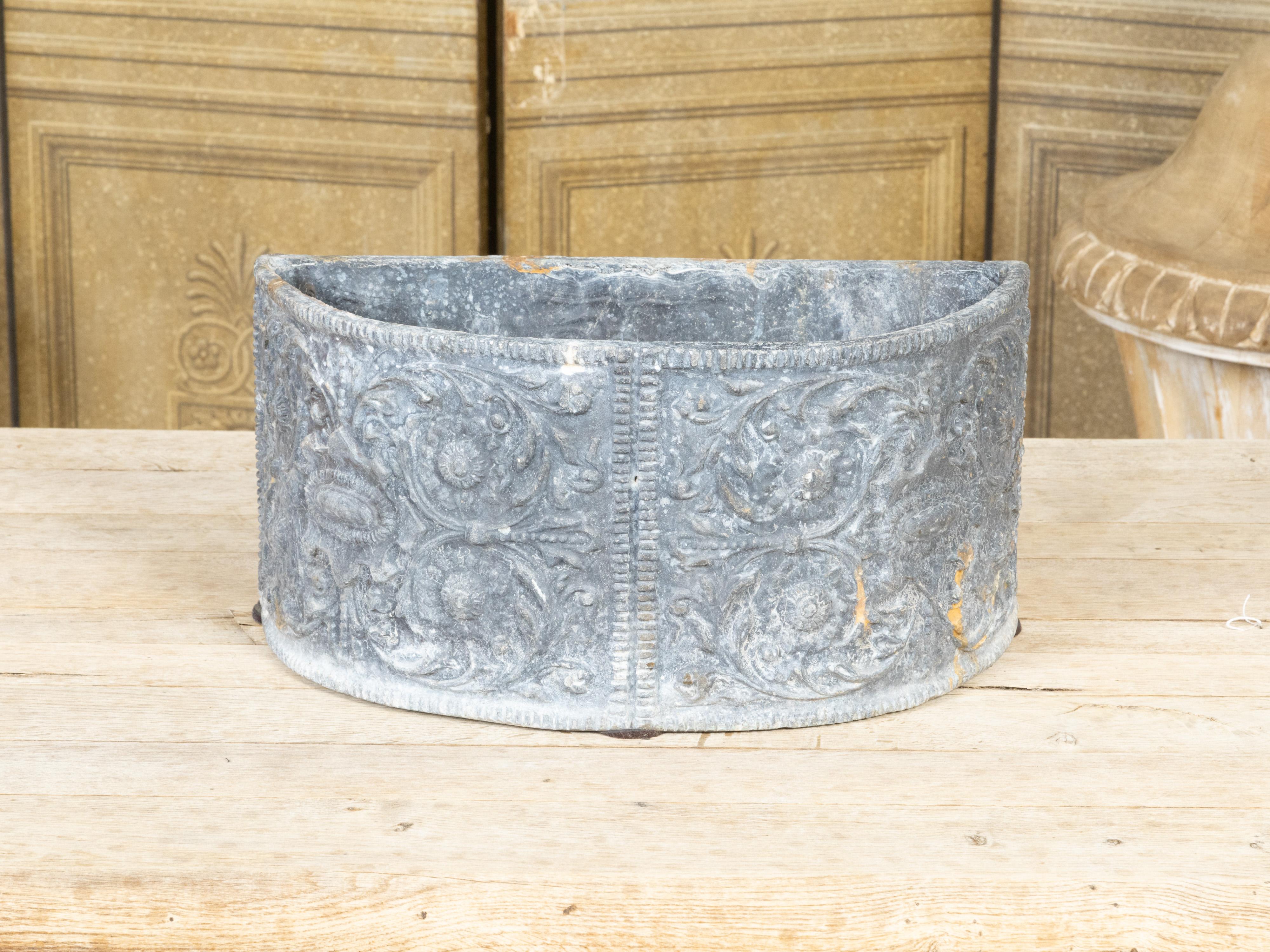A French semi-circular lead jardinière from the early 20th century, with scrollwork of foliage and nicely weathered patina. Created in France during the Turn of the Century which saw the transition between the 19th to the 20th, this lead jardinière