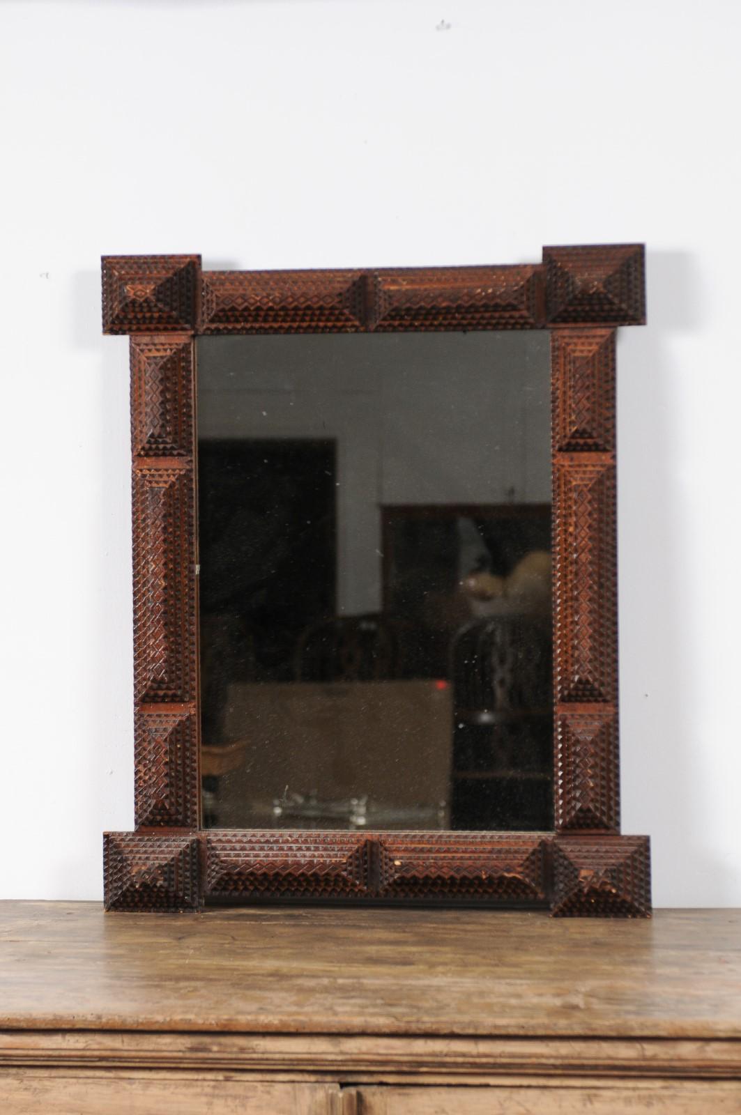 A French Tramp Art hand carved mirror from the Turn of the century, with pyramidal motifs. Born in the early years of the 20th century, this charming wall mirror was hand carved in the manner typical of the Tramp Art style. Presenting a linear
