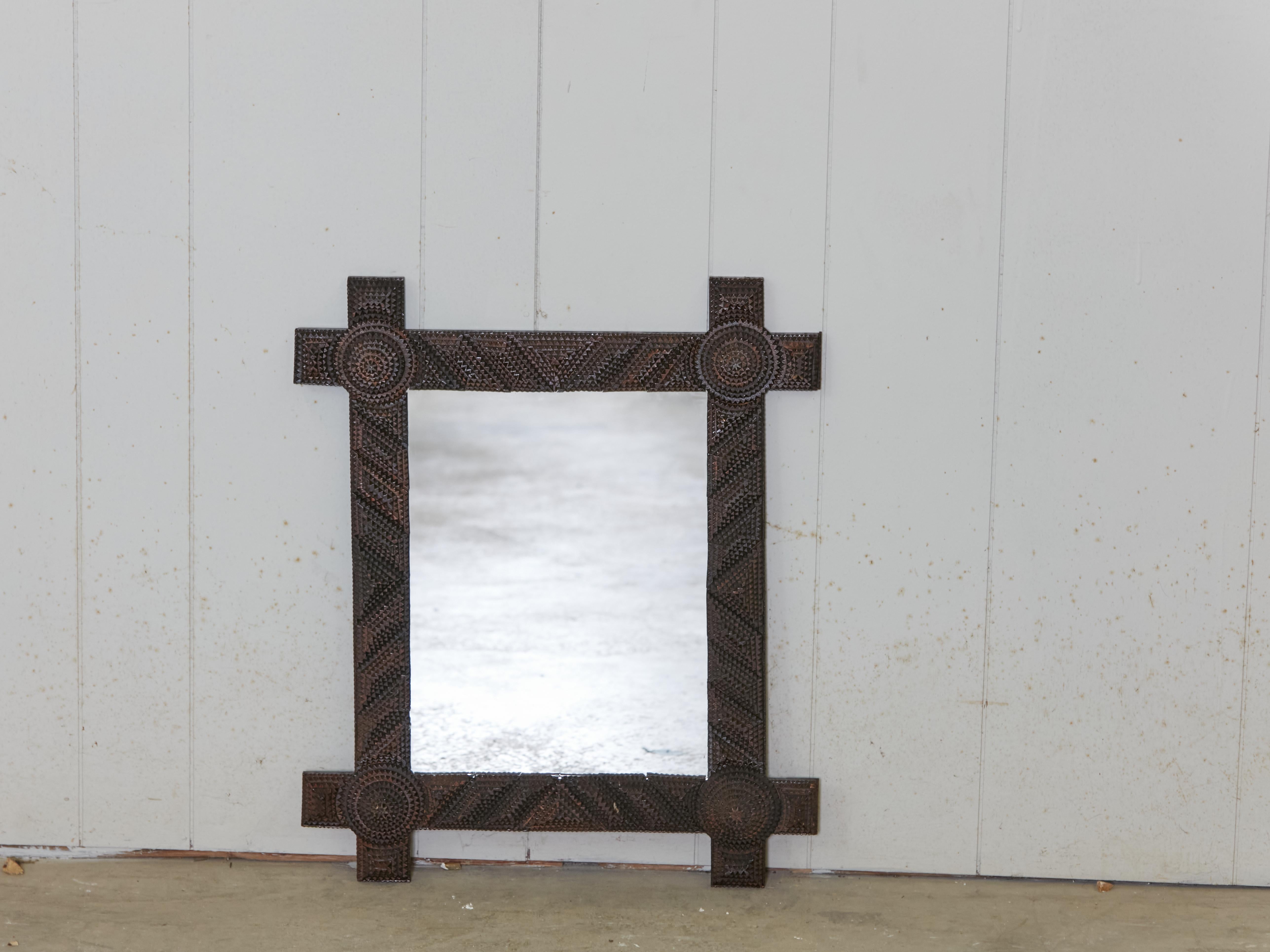 A French Turn of the century Tramp Art hand-carved mirror from the early 20th century, with raised concentric corners, geometric motifs and dark brown patina. Created in France during the Turn of the Century which saw the transition between the 19th