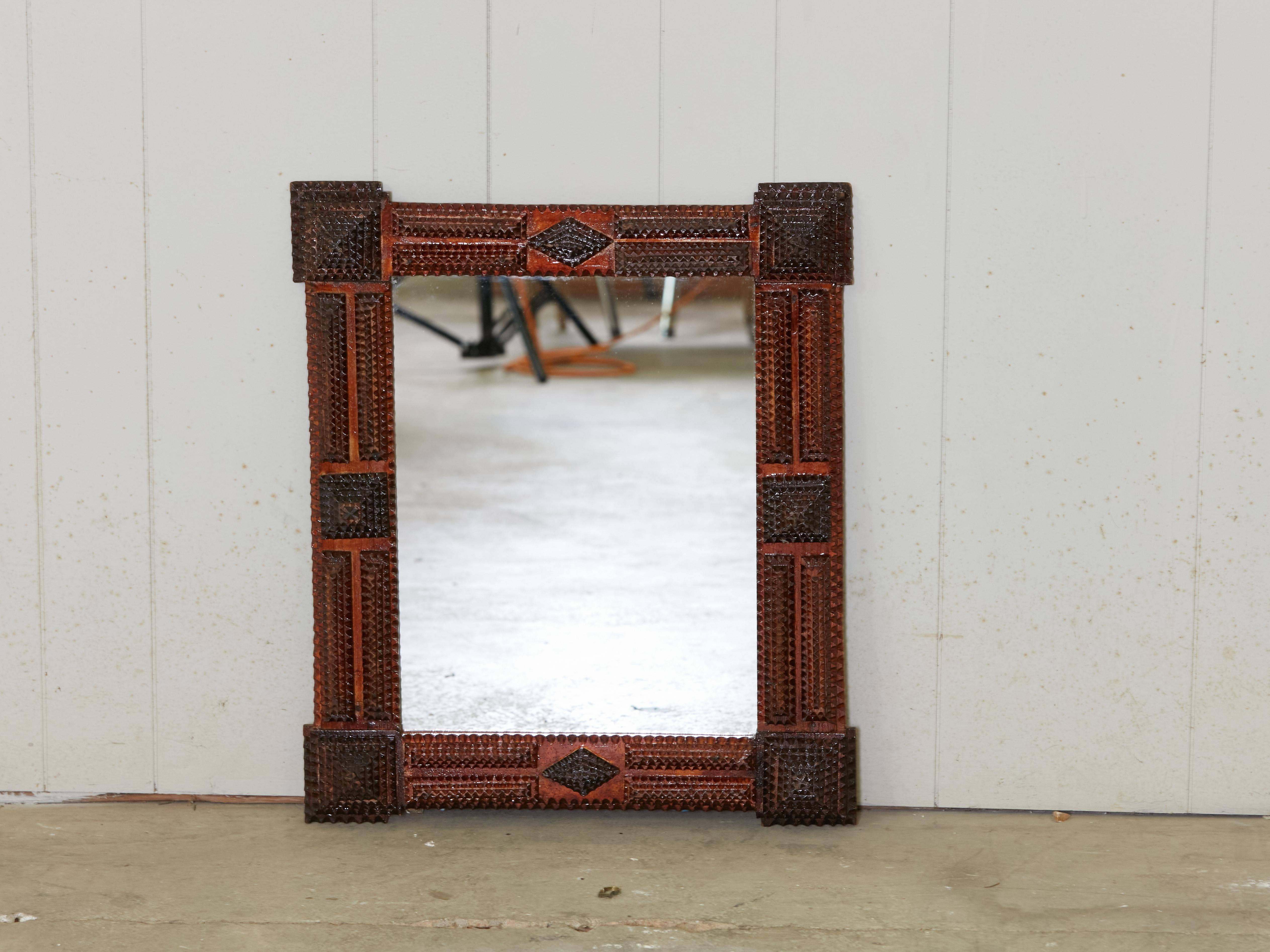 A French Turn of the century Tramp Art hand-carved mirror from the early 20th century, with protruding corners, raised pyramidal motifs and reddish brown patina. Created in France during the Turn of the Century which saw the transition between the
