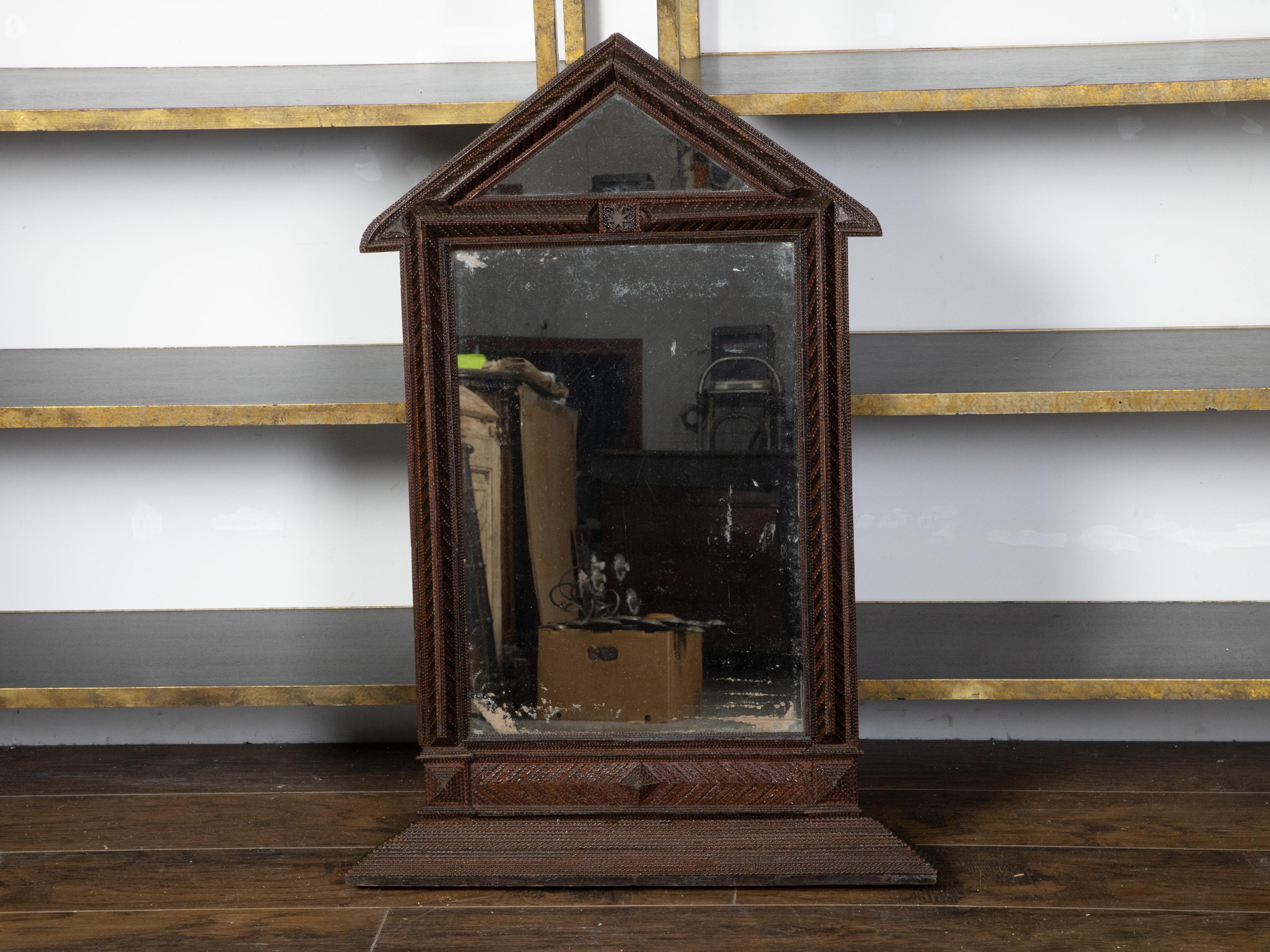 A French tramp Art hand-carved mirror from the early 20th century, with triangular pediment and pyramidal accents. Created in France during the Turn of the Century, this mirror was hand carved in the manner typical of the Tramp Art style. Consisting