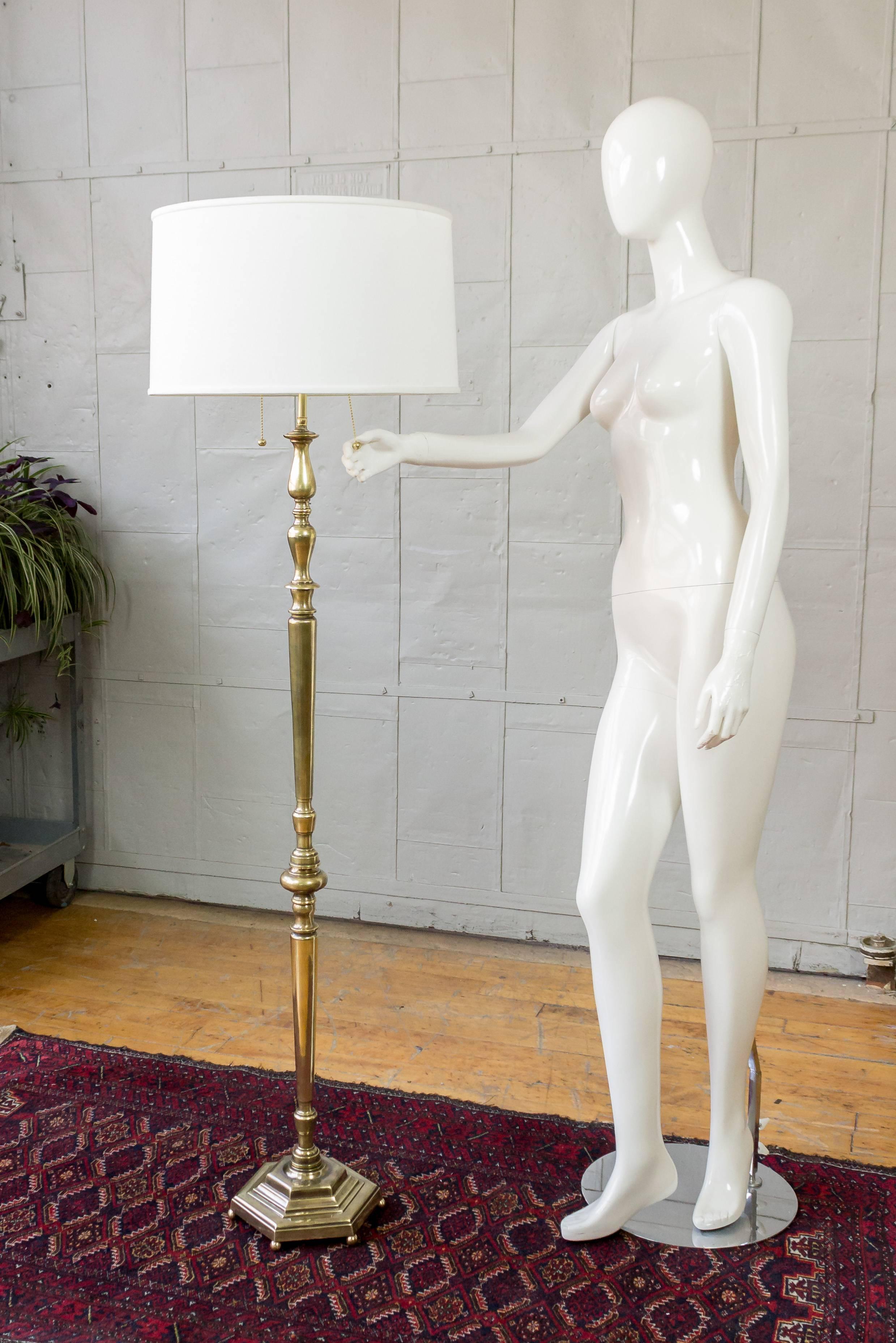 Recently refinished handsome brass floor lamp with turned and cast bronze parts. The hand finished finish shows variations in the patina to bring out the age of the piece but overall the lamp retains a butler or English brass tone. The floor lamp
