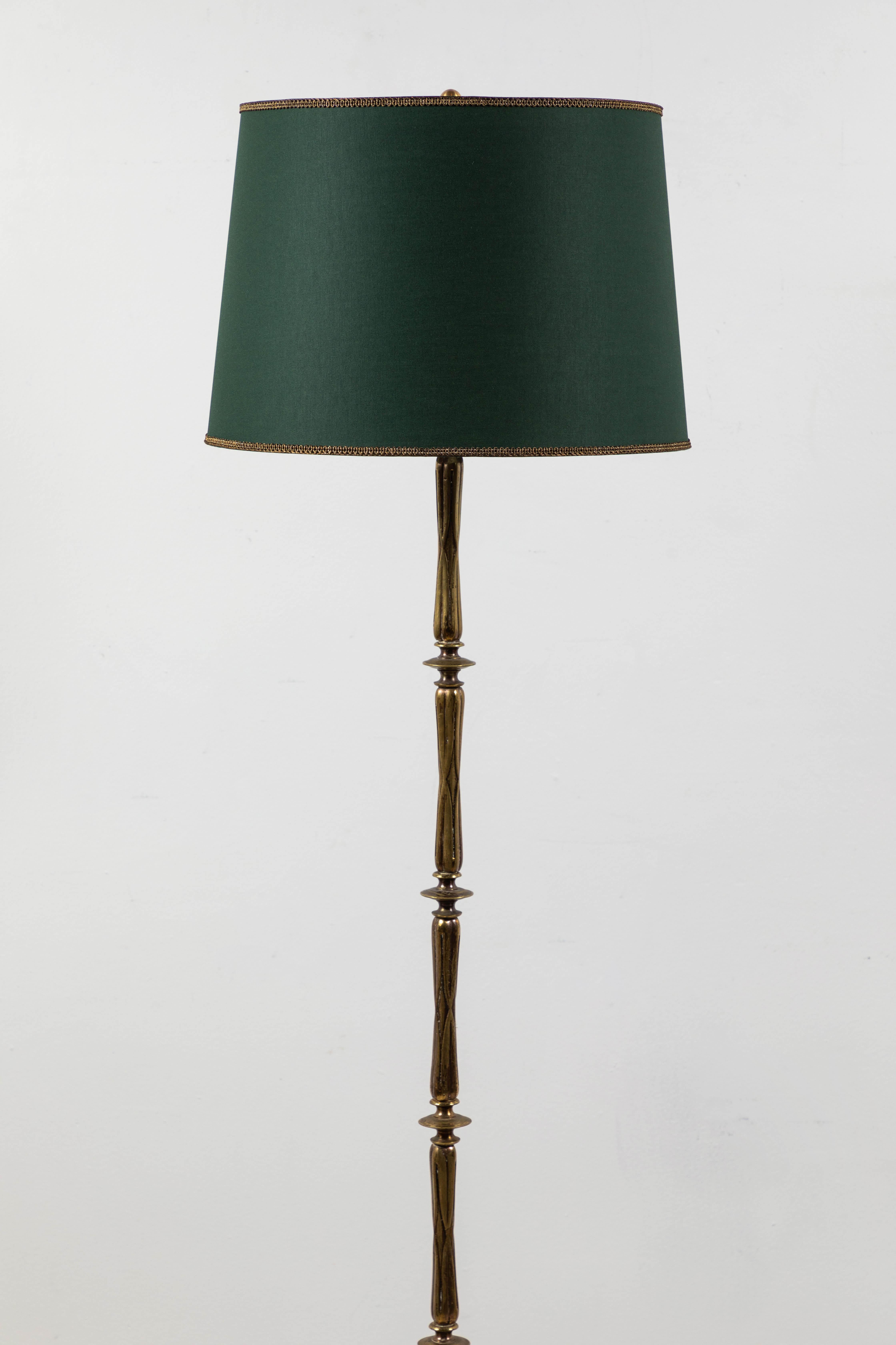 French turned brass floor lamp with tripod base and green book cloth shade with gold trim.