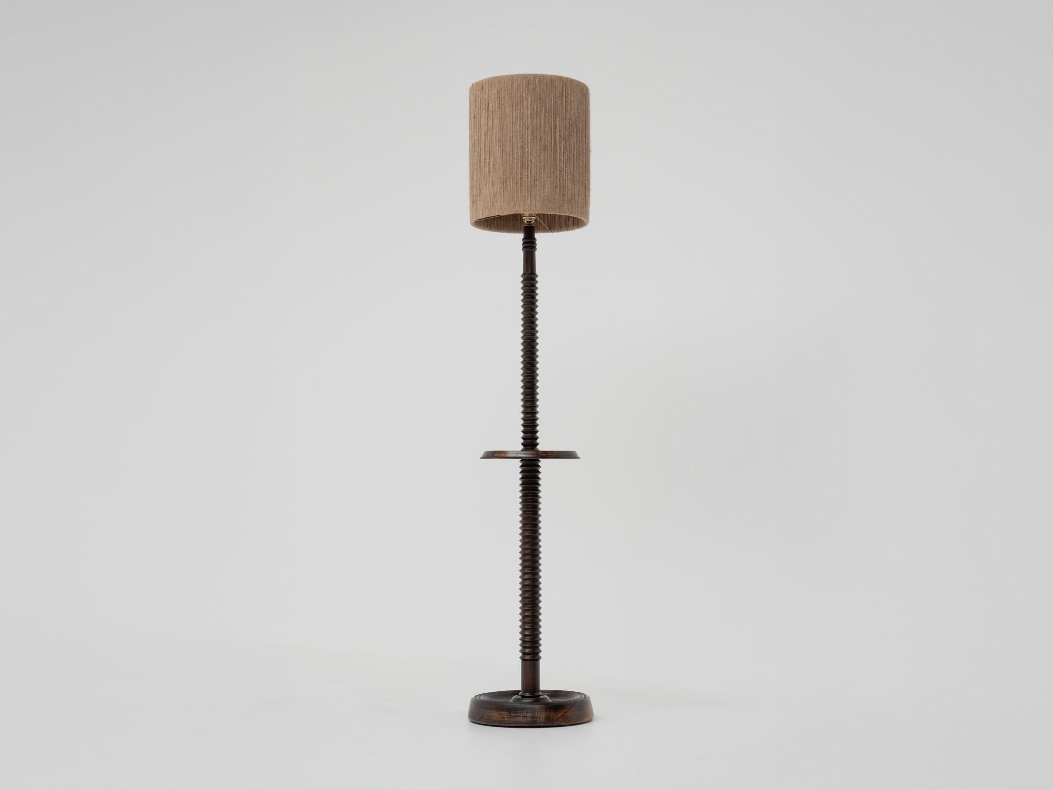 This is a beautiful French antique floor lamp from the 50s. To modernize the lamp while preserving its vintage charm, we have chosen a new rope lampshade that enhances the warm tones of the patinated wood, creating a delightful blend of classic and
