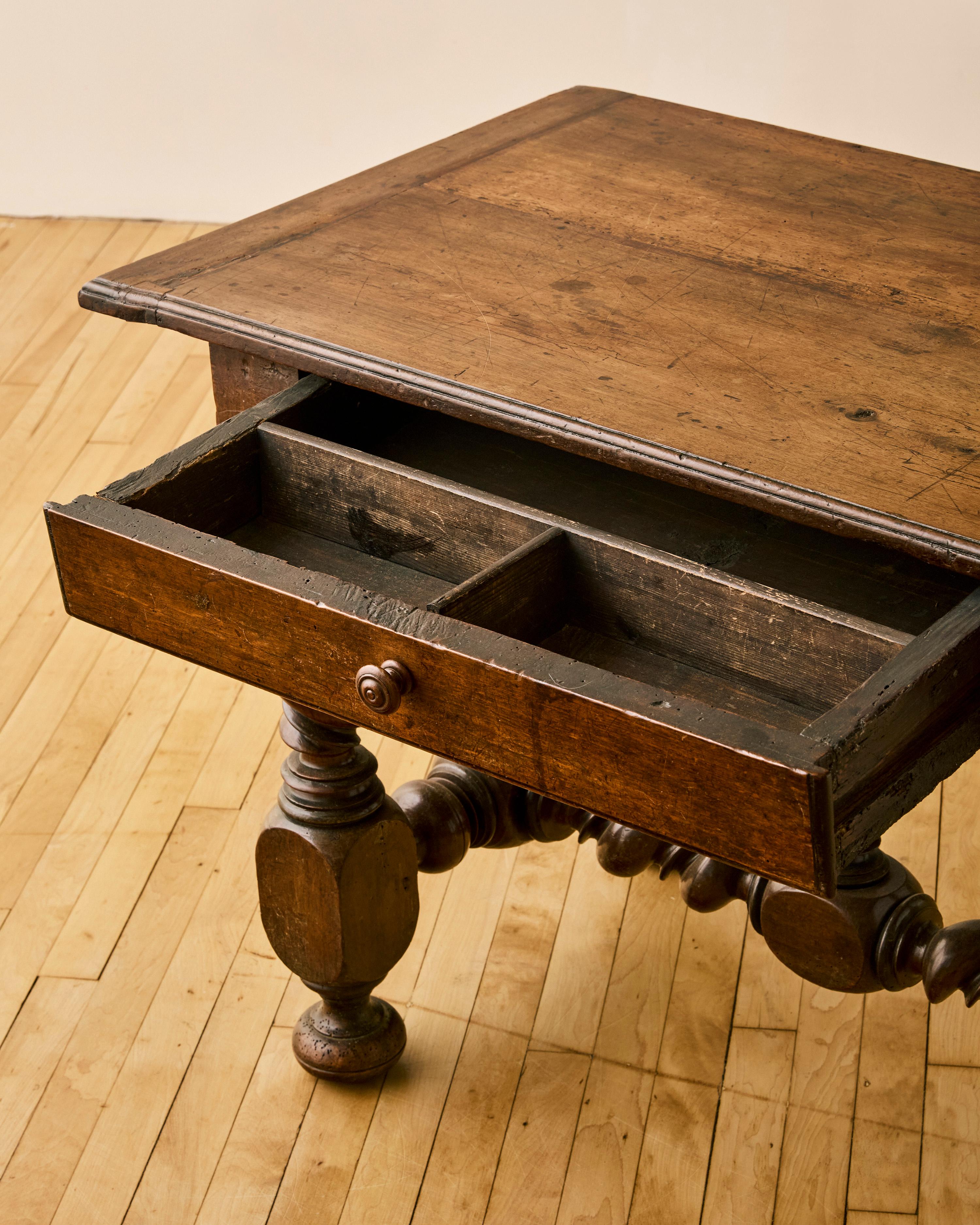 French Louis XIII style turned wood base writing table featuring a central finial.