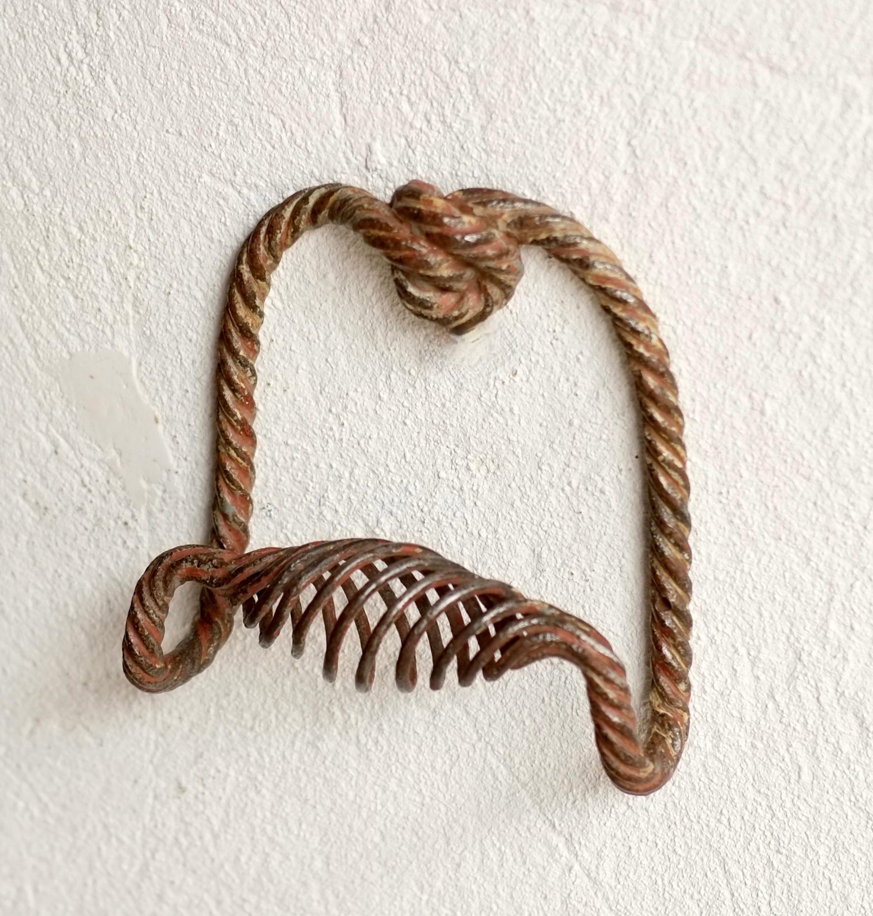 A twisted iron handle featuring a decorative knot at the top of the handle. 

French, late 19th / early 20th century. 

Can be mounted at any angle.

H 16 W 15 D 6.5 cm