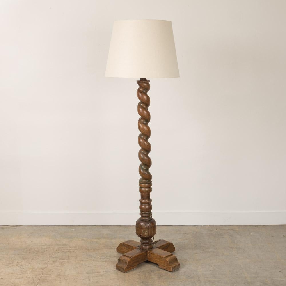Wonderful vintage twisted wood floor lamp from France, 1940's. Large twisted wood stem and cross base. Original finish shows wonderful age and patina. Natural cracks in wood add great character. Newly re-wired with exposed brown cloth cord running