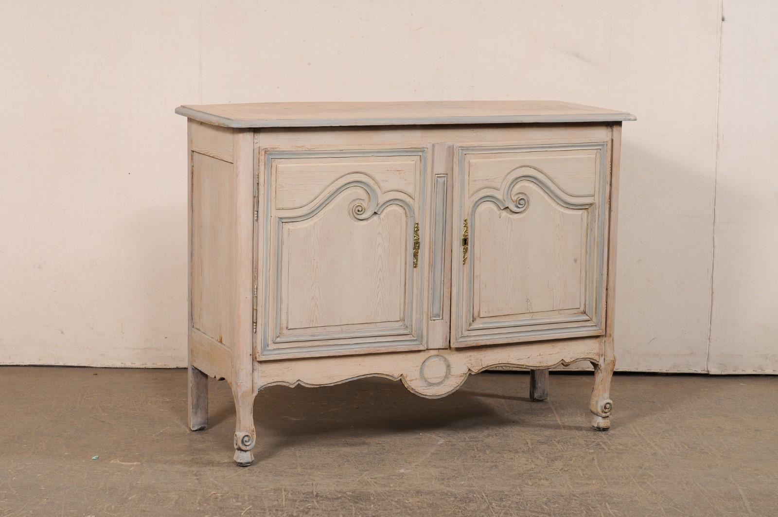 Mobile buffet francese a due ante in legno intagliato e dipinto del XIX secolo. Questo mobile antico proveniente dalla Francia presenta un piano rettangolare con angoli anteriori dolcemente arrotondati, sopra una cassa che ospita una coppia di ante