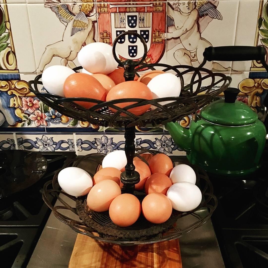From France, circa 1890-1910, a two-tiered form, twisted wire egg stand basket. The two baskets are held by a painted metal centre spindle with a top ring toting handle. The base is painted brass, unfinished on the underside. The baskets are made of