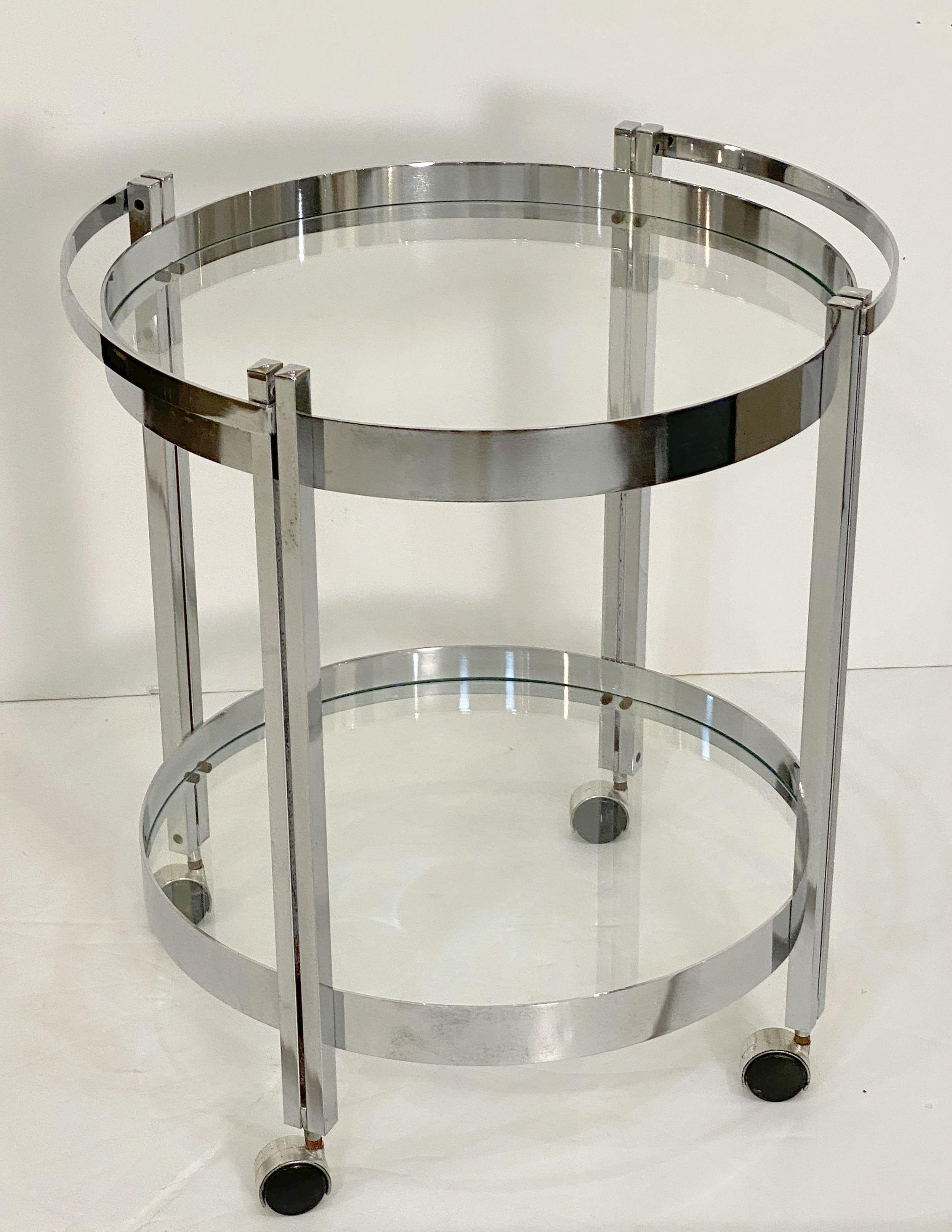 A fine French round or circular table of chromed steel with two concentric circle tiers of inset glass, set upon rolling casters.

Great as a drinks trolley or bar cart as well.