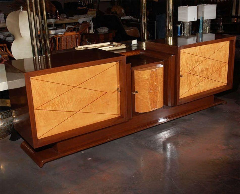 French Art Deco buffet with a Modernist twist. Note the geometric inlay design on the side cabinets. Main body is walnut with tiger maple fronts and maple interiors. Center section has an Art Deco floral frieze. It opens up to three drawers with