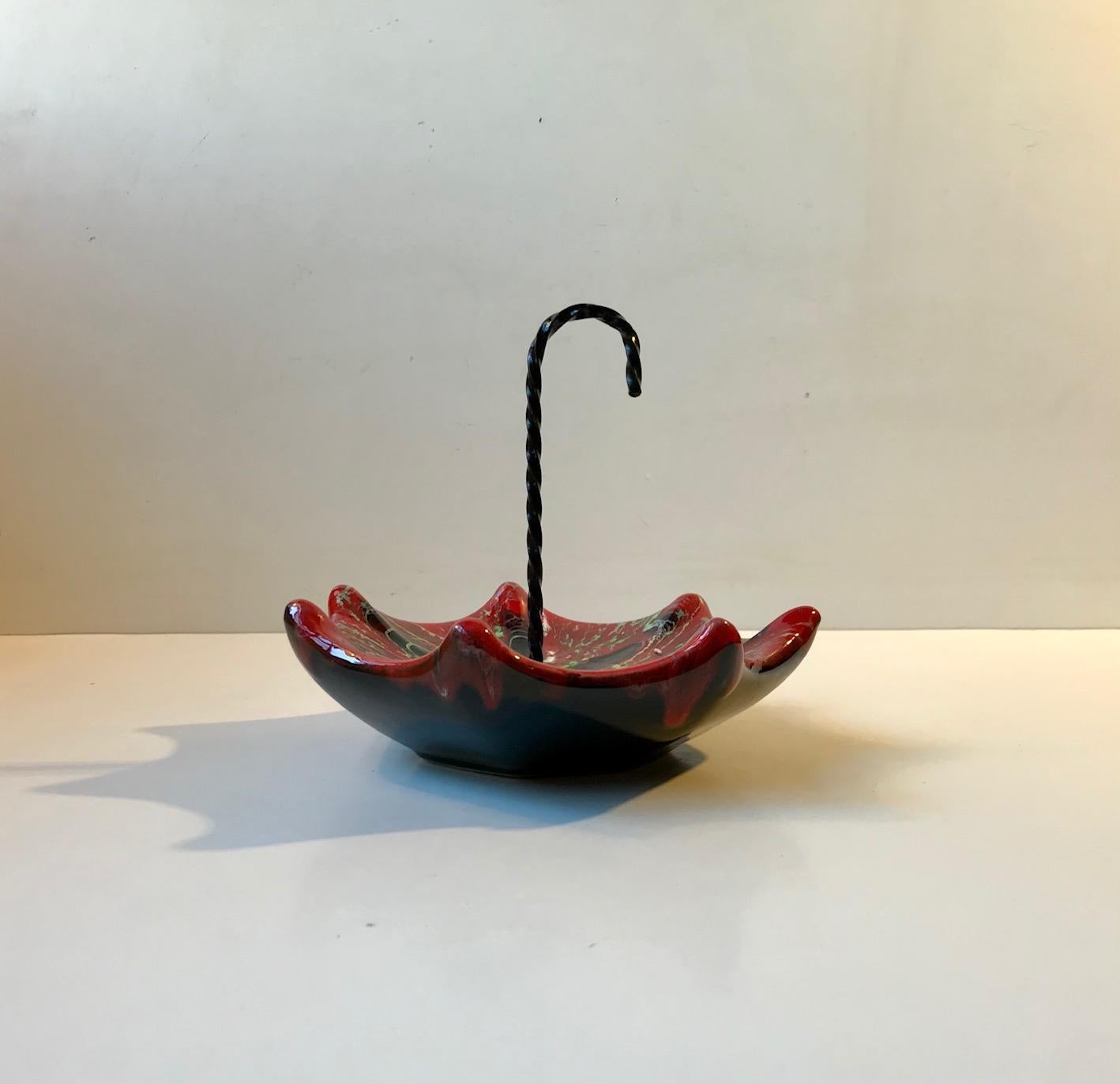 Curious ceramic dish/tray shaped as an upside down umbrella. It features a twisted metal handle and psychedelic glaze. Designed and manufactured by Vallauris in France during the 1960s. Measurements: W/D: 17, H: 15 cm with handle.