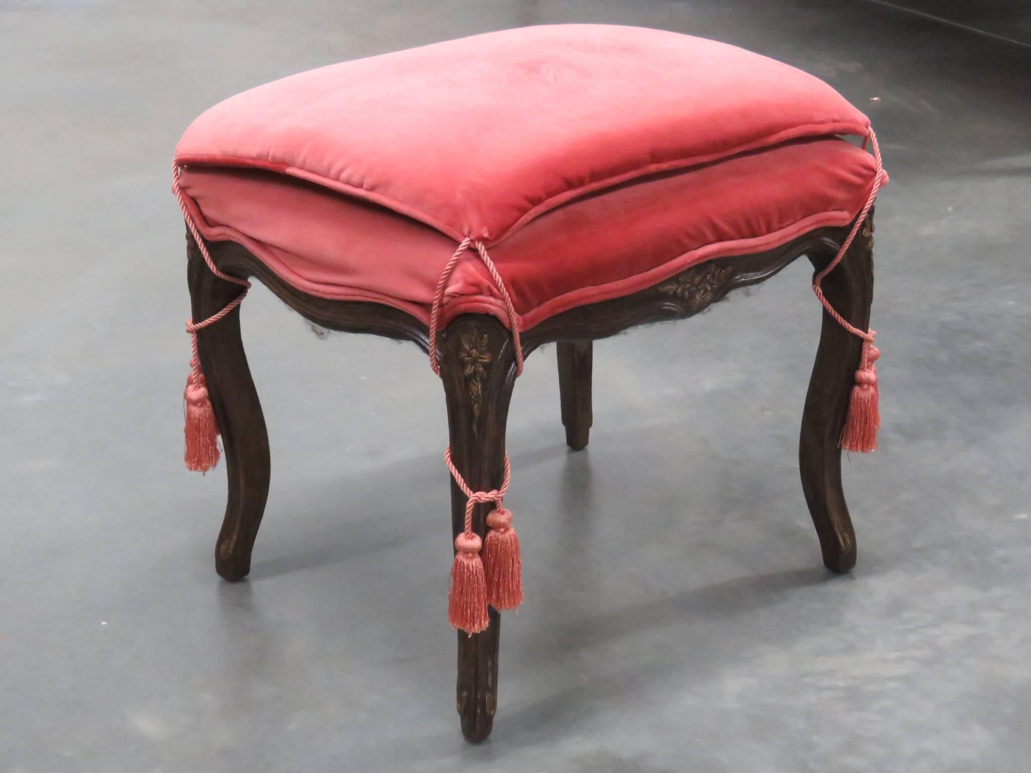 French upholstered stool with carved wood frame.