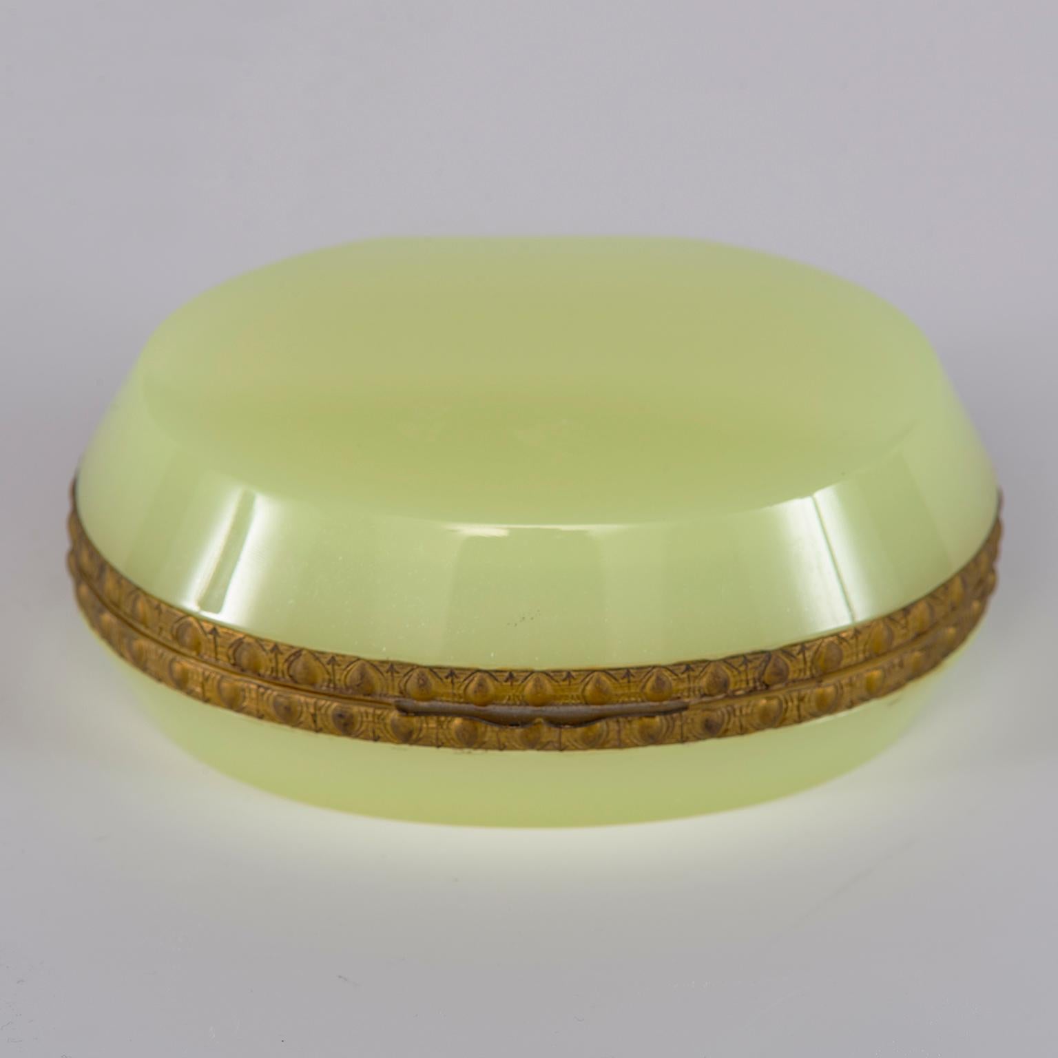 French uranium opaline glass hinged box is oval shaped with fancy brass trim. Unknown maker, circa 1920s.