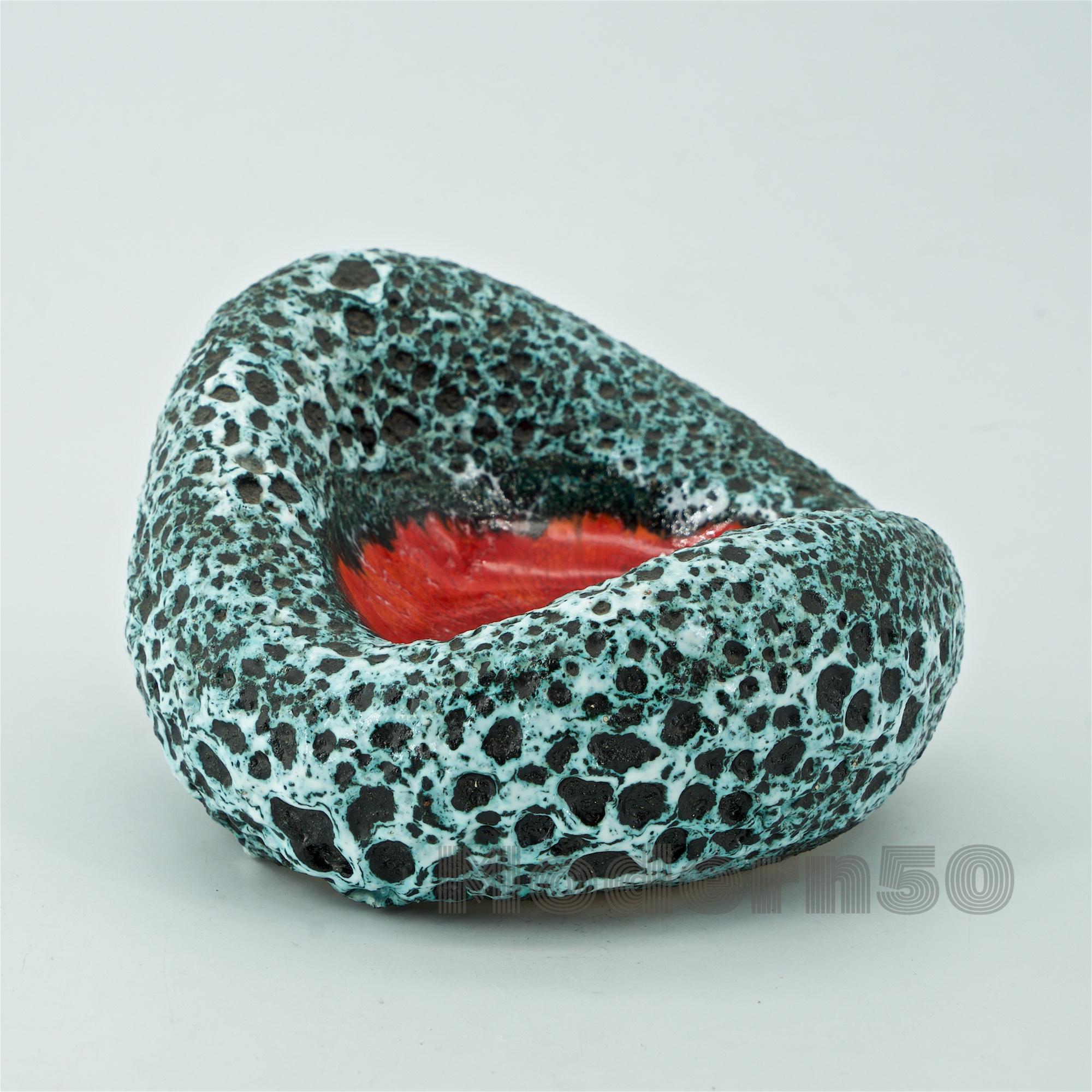 In the manner of Georges Jouve, an organic form with volcanic lava black and white glaze and a high-gloss red center.