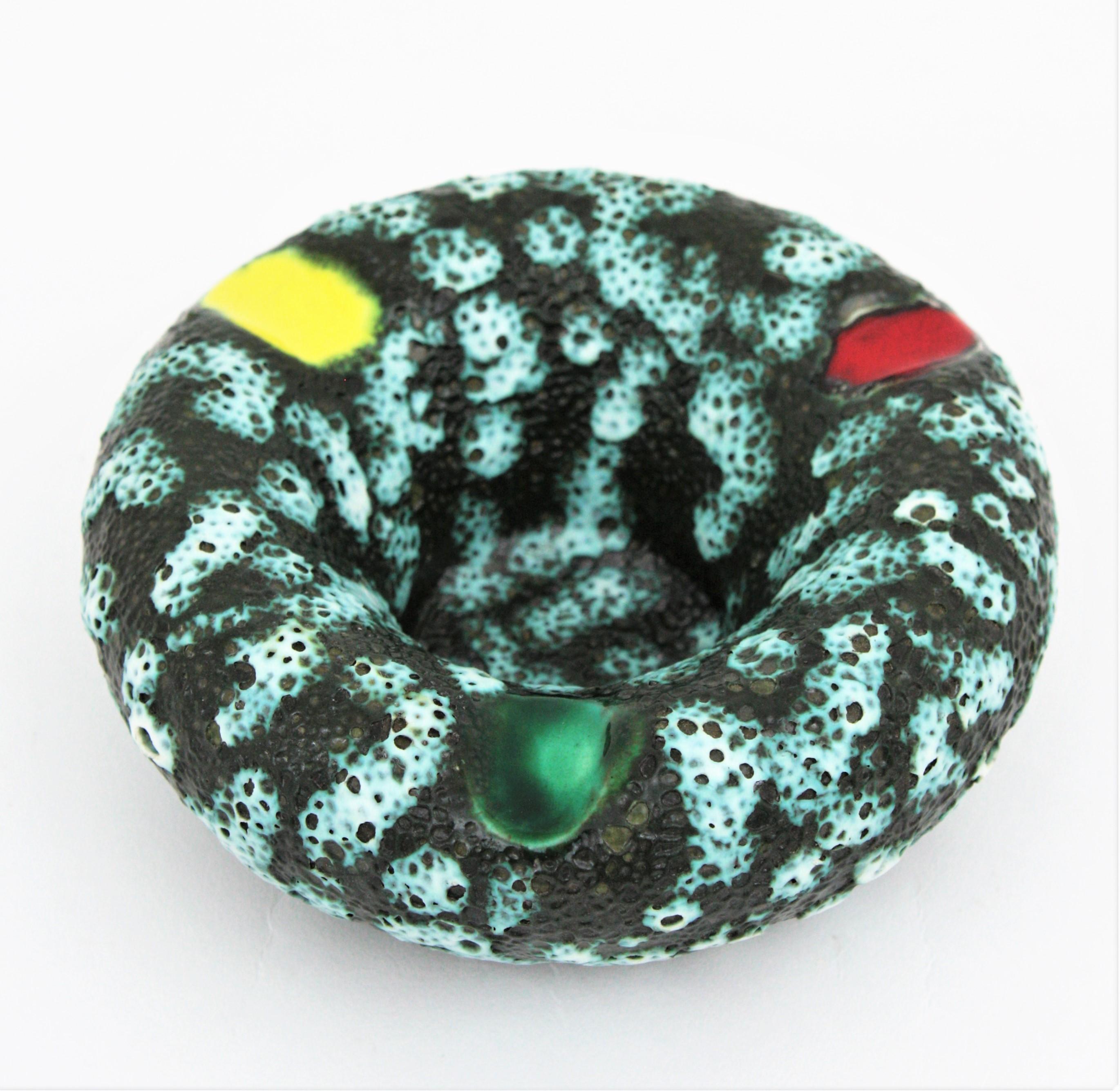 Beautiful fat lava and glazed ceramic ashtray with three colorful bands manufactured by Vallauris. France, 1950s.
This cool ashtray was handcrafted in France at the mid-20th century period. Its design in turquoise and grey fat lava ceramic with