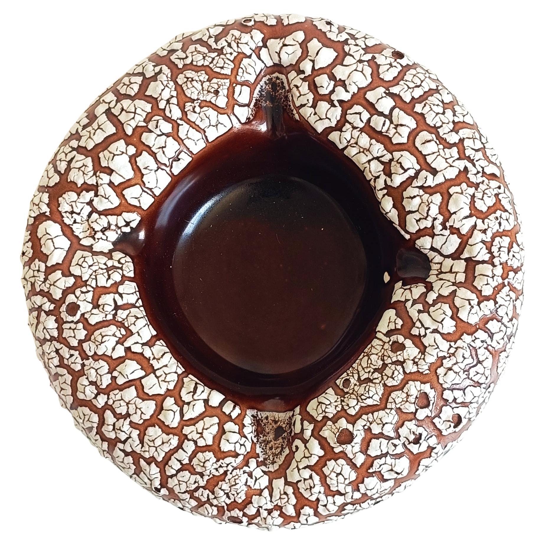 This striking Mid-Century Modern French Vallauris ceramic ashtray, or vide-poche, was handcrafted in France in the 1950s and exemplifies the bold design aesthetic of the era. Its organic, biomorphic form immediately catches the eye, showcasing the