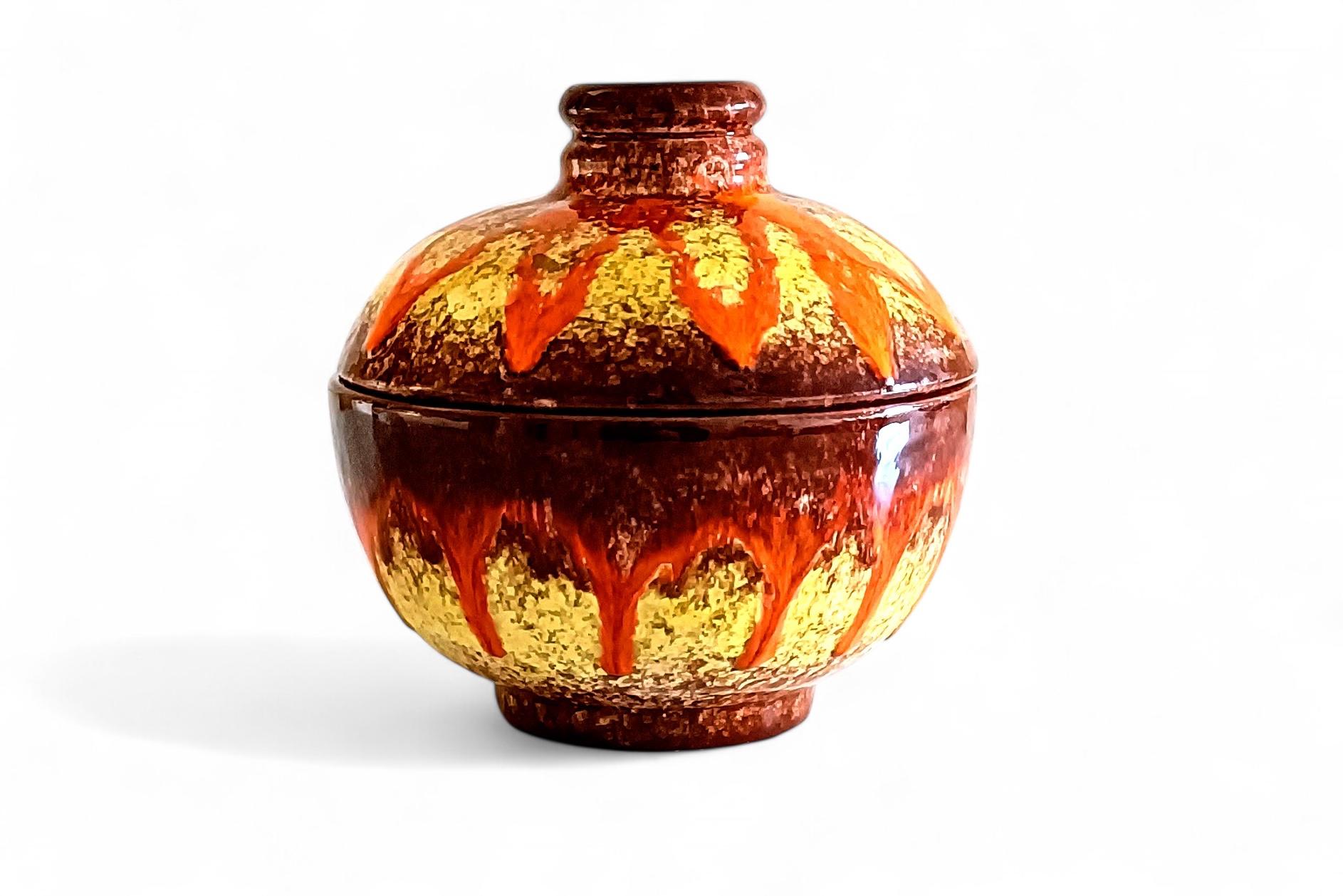 Encantador cuenco o jarra de mayólica con tapa que presenta un bello vidriado de lava grasa en vivos colores naranja, amarillo y marrón. Tamaño y forma encantadores. 

Fabricada a mano en Vallauris, sur de Francia, hacia la década de 1950.

En