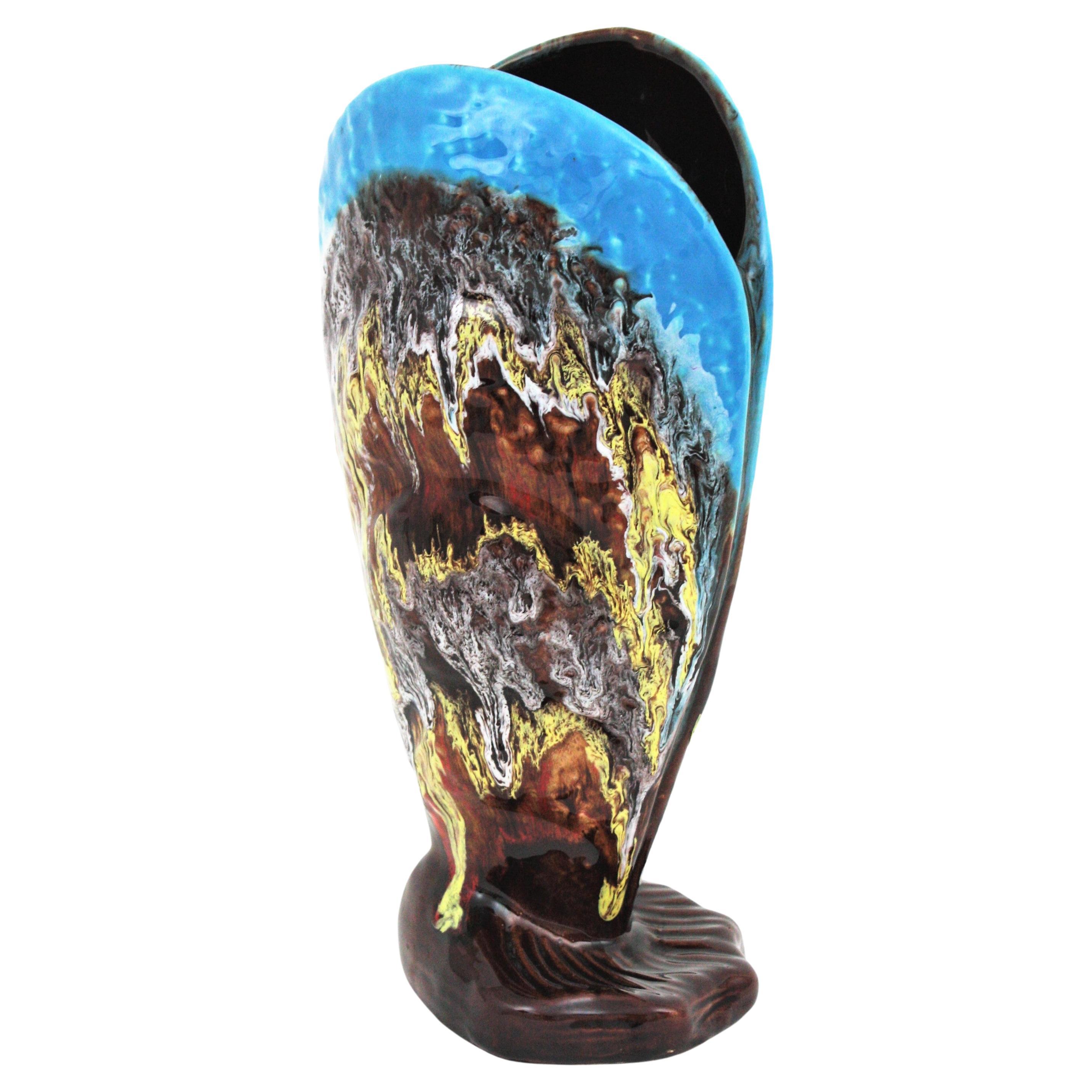 Giant Mid-century Modern Vallauris Ceramid Shell Shaped Vase. France, 1950s-1960s.
Colorful vase with mussel / shell design in glazed ceramic. The exterior part is covered by glazed ceramic in brown color with fat lava decorations in beige, yellow