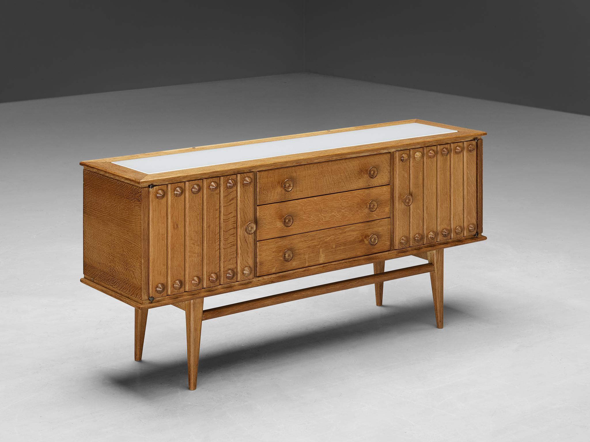 Vanity, oak, brass, France, 1960s

French vanity with large mirror made in oak with beautiful grain and detailing. With the vividly designed fronts and the functional and versatile storage facilities this high-quality piece of furniture serves both