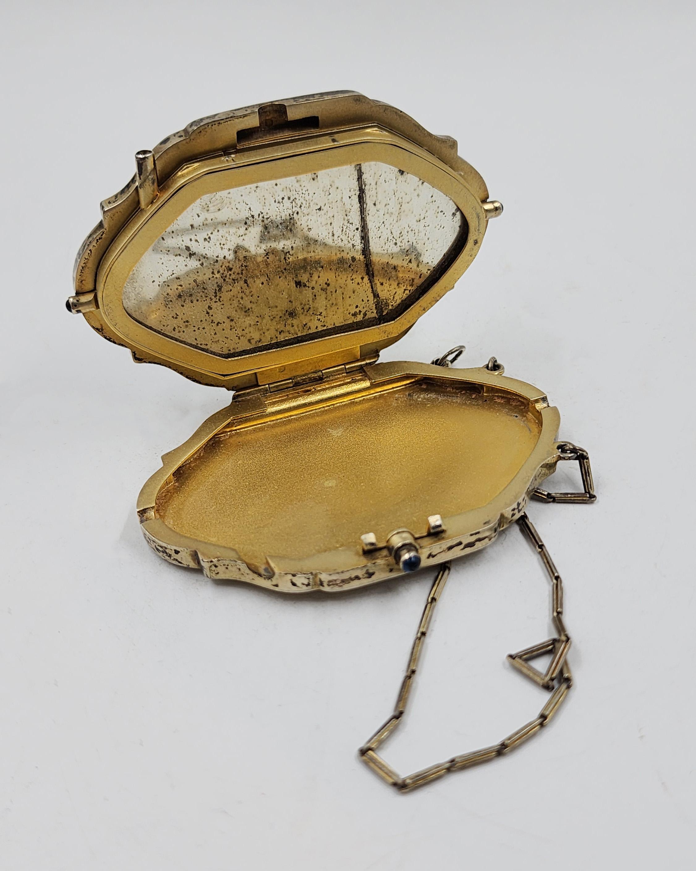 Französischer Waschtisch aus Sterlingsilber mit Emaille-Design
Dieser Waschtisch aus französischem Sterlingsilber hat die Form einer ovalen Kartusche mit geschwungenen Rändern. Der Deckel ist mit einer handgemalten Emaille-Szene verziert, die eine