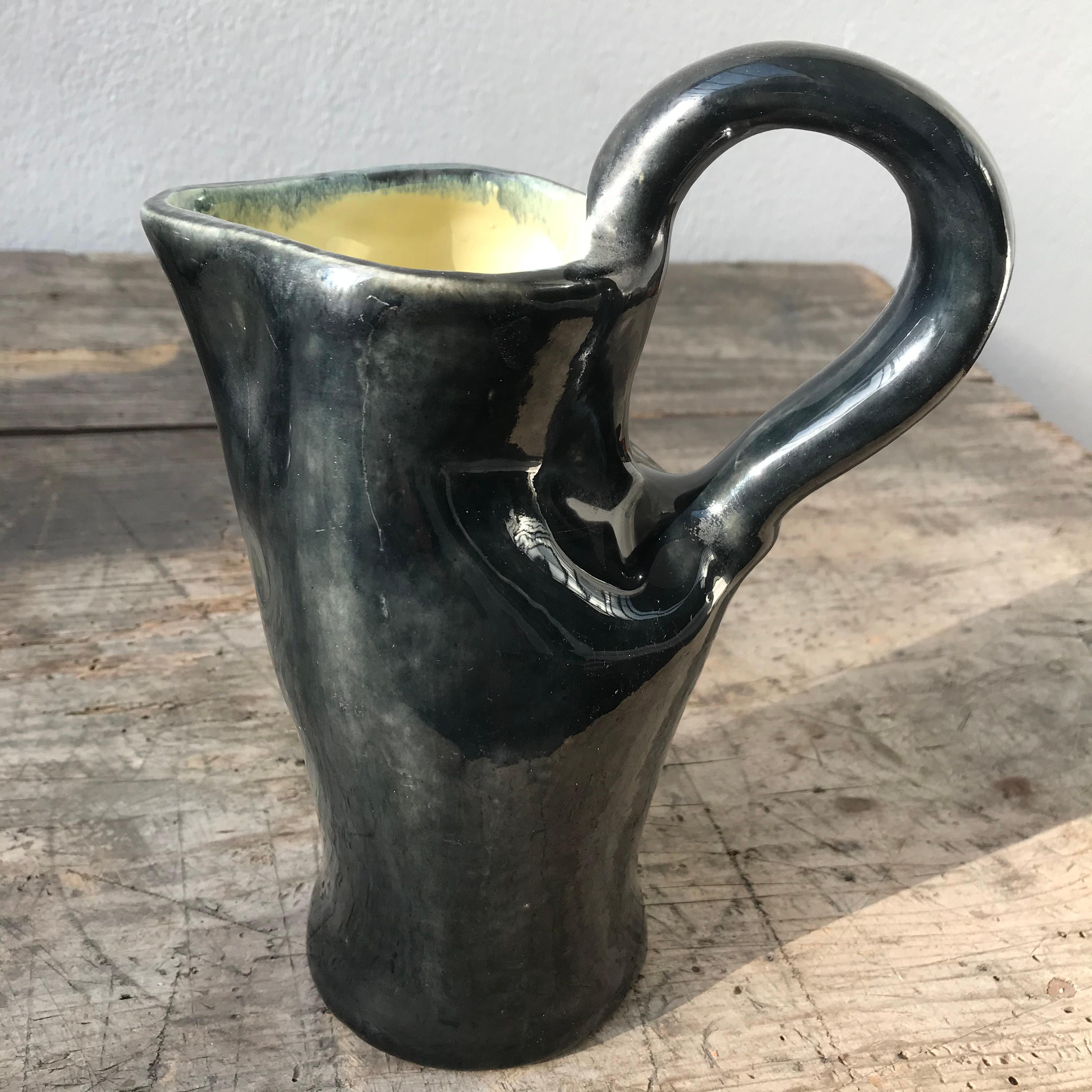 Realza tu espacio con este jarrón de cerámica negra con un interior amarillo chillón: es una llamativa pieza de artesanía y diseño contemporáneo.