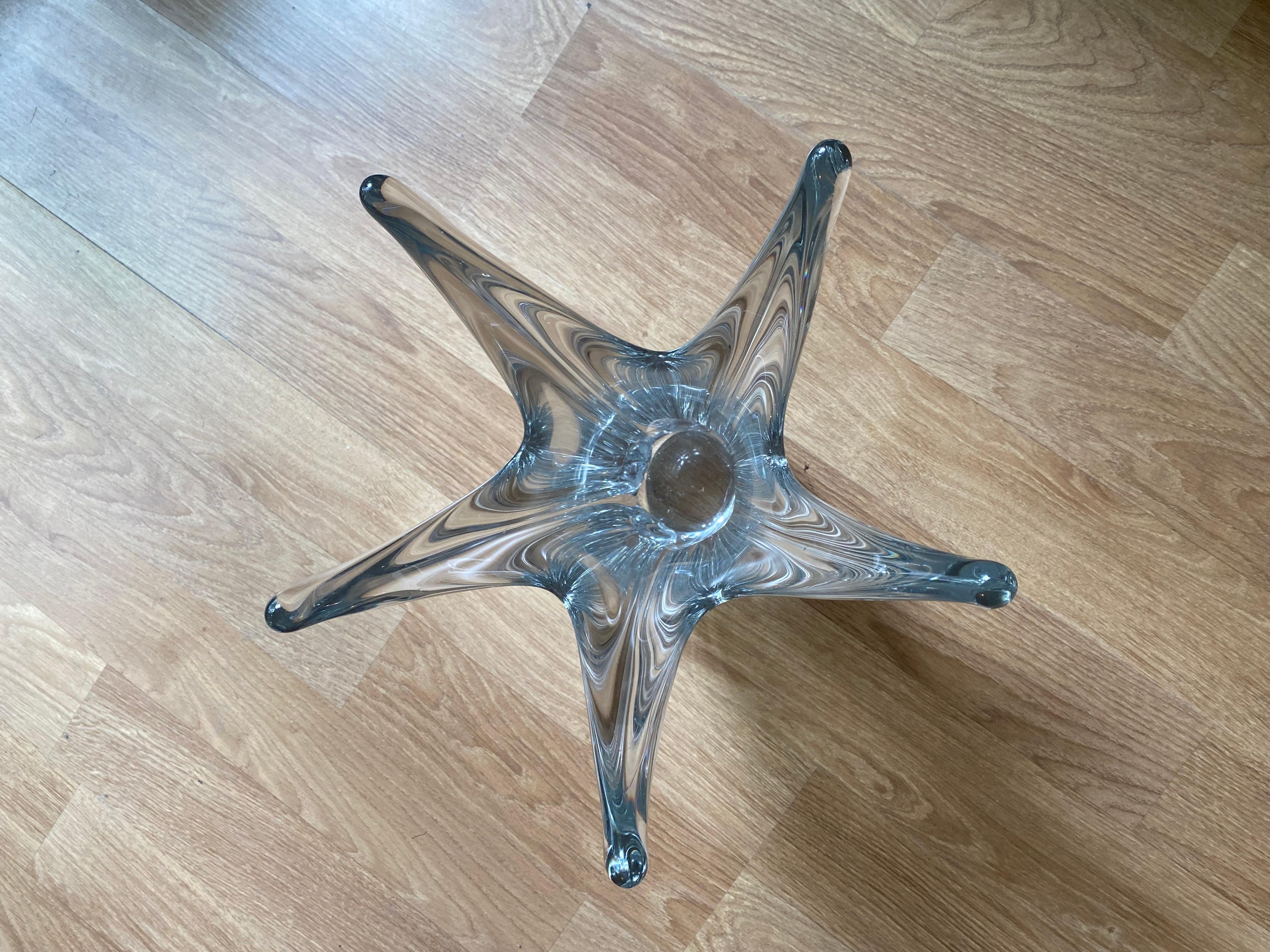 Vase en verre transparent des années 1950, signé sur la base par la prestigieuse société française Daum. Cette marque provient d'une ancienne usine que Jean Daum (1825 - 1885), expatrié alsacien depuis 1870, avait achetée à Nancy en 1875. Ses