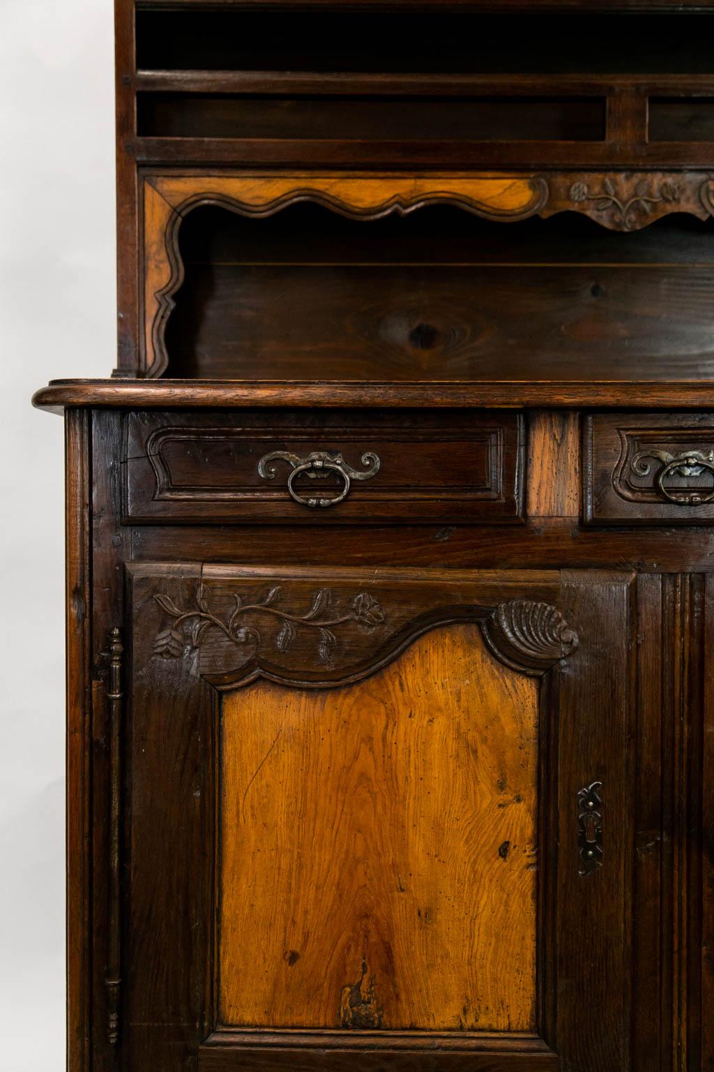 The top of this oak vassiliere has a carved arch and central apron. The doors are carved oak with recessed fruitwood.