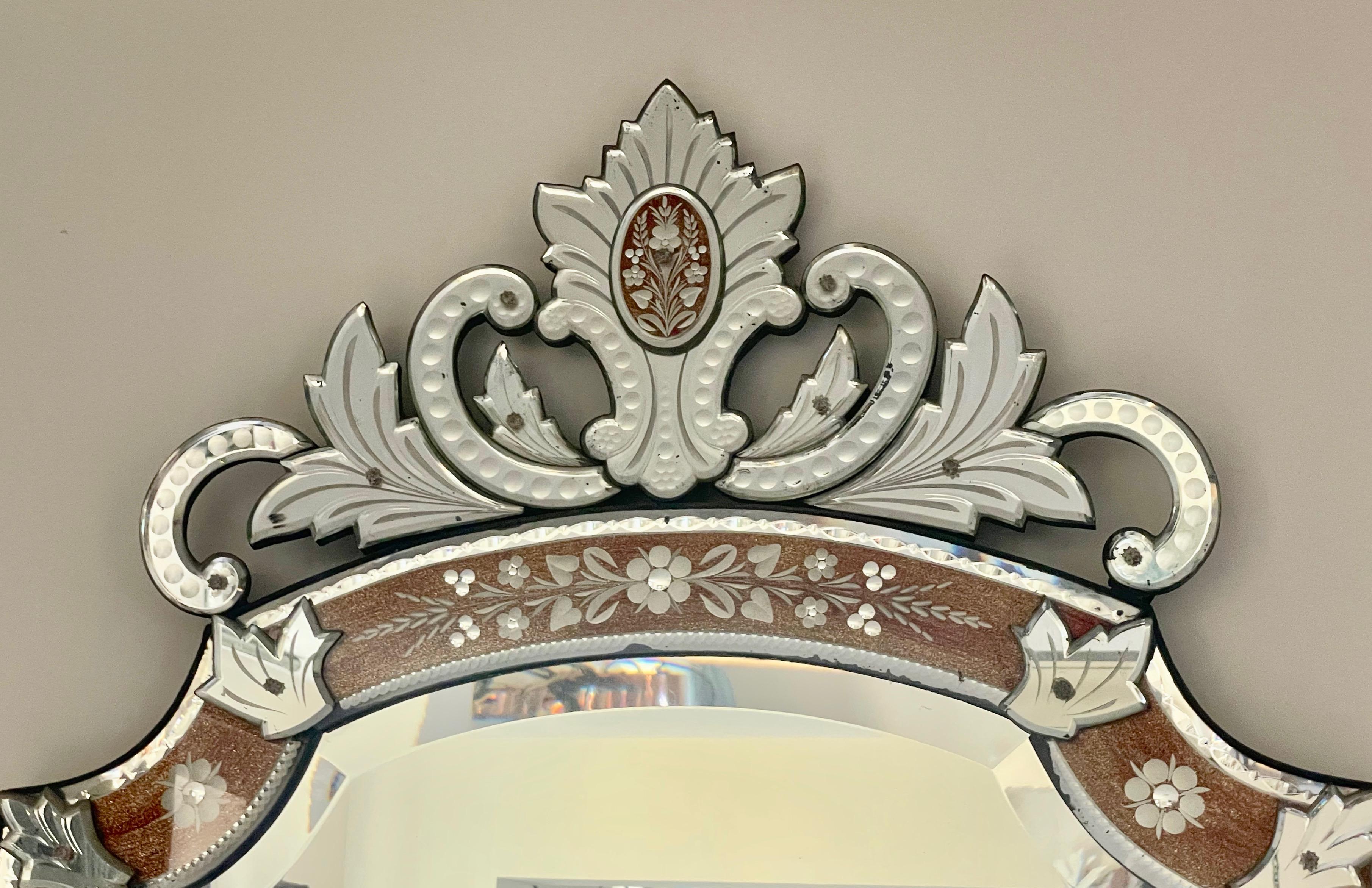A tall Venetian style pier mirror, with a scrolling and foliate mirror crest, centred with a dark gold glitter ground cartouche.
The borders also with dark gilt ground, and engraved floral eglomisée frame, France, circa 1890.