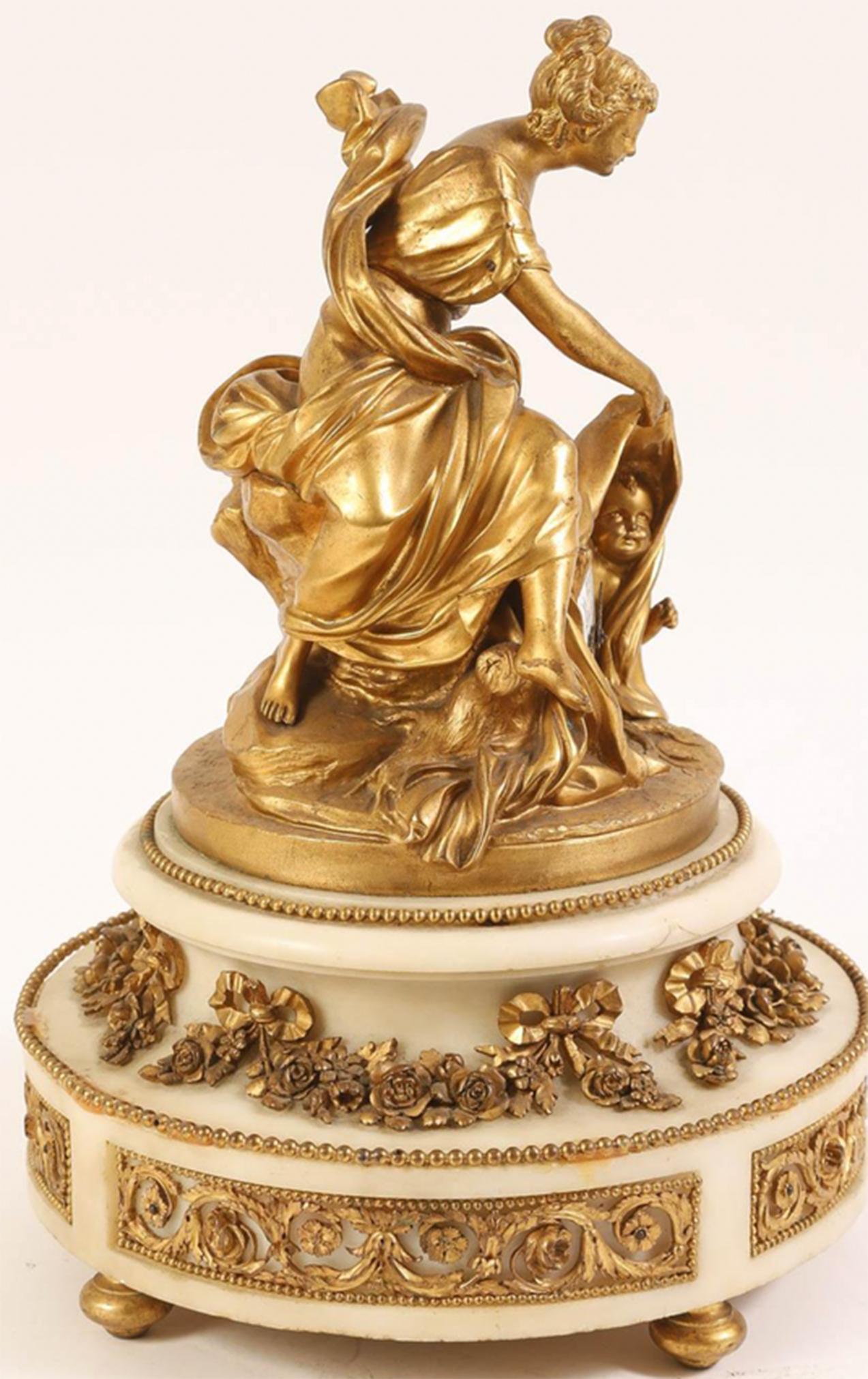 French Venus and Cupid Gilt Bronze and White Marble Mantle Clock by Planchon - Au Palais-Royal 

Crafted in the Louis XV style this gilt bronze and white marble mantle clock depicts Venus and Cupid mounted on a marble pedestal base with floral