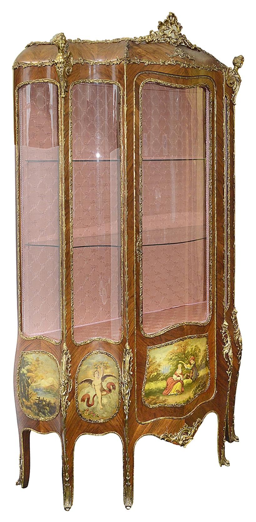 A good quality late 19th century French Louis XVI style bombe fronted vitrine, having classical gilded scrolling foliate and monopodia ormolu mounts, shaped and bowed glass pains and door, hand painted panels depicting lakeland scenes, classical