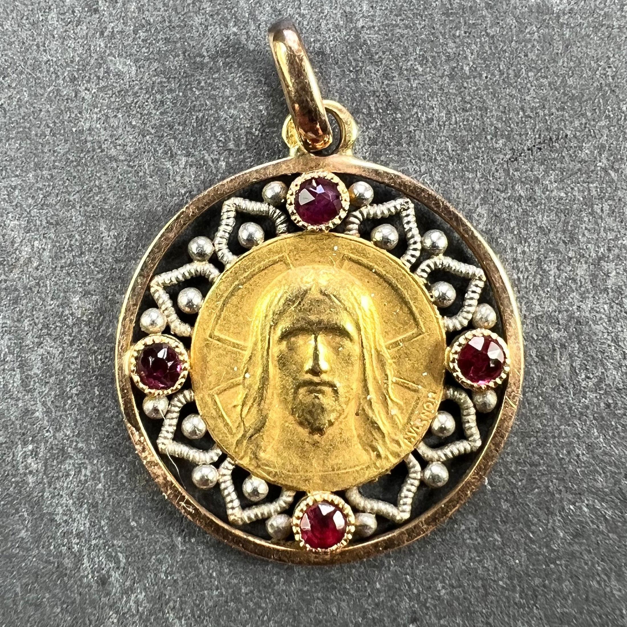 Colgante de oro amarillo de 18 quilates (18K) con una medalla de oro que representa el rostro de Jesucristo con una cruz. El reverso representa al cordero de Dios con una cruz sobre un fondo de cruces. Firmado F. Vernon. La medalla está dentro de un