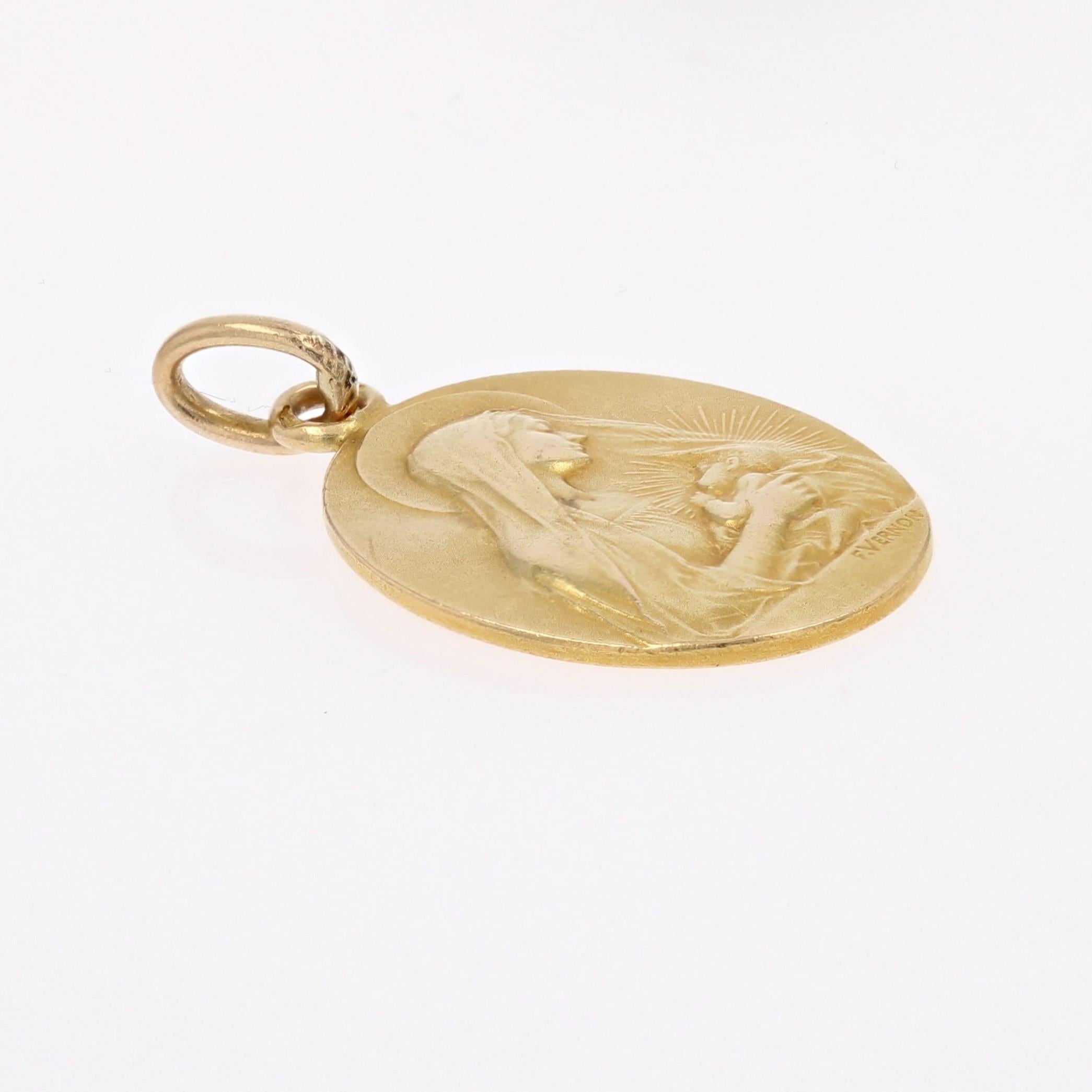 Medal in 18 karat yellow gold, eagle head hallmark.
Antique oval shape medal, it represents the Virgin with the Child. This religious pendant is signed F. Vernon.
The back is engraved : 