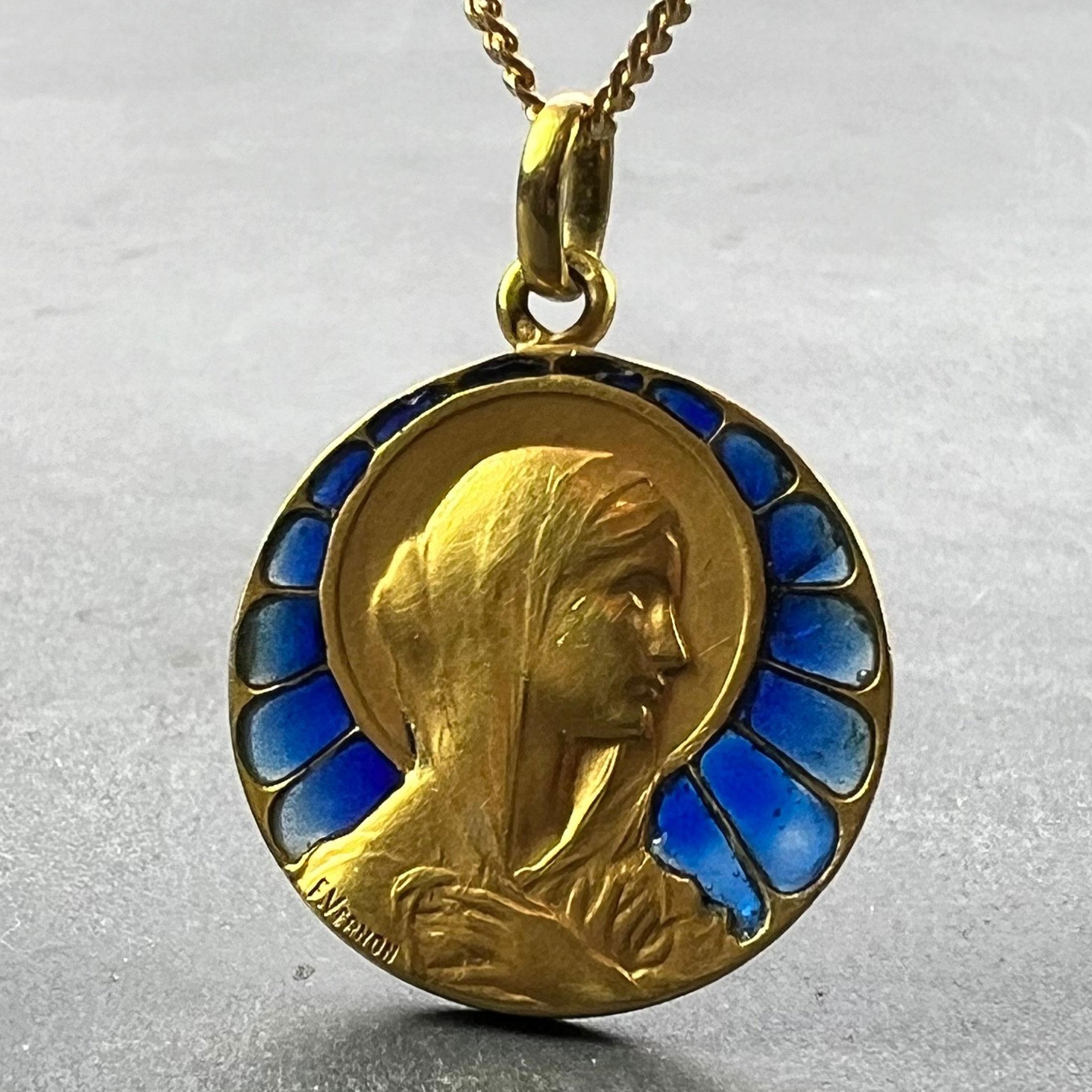Colgante francés de oro amarillo de 18 quilates (18K) diseñado como una medalla redonda que representa a la Virgen María con un halo que sujeta su velo sobre los hombros. Engastado con esmalte azul plique-a-jour para representar una vidriera.
