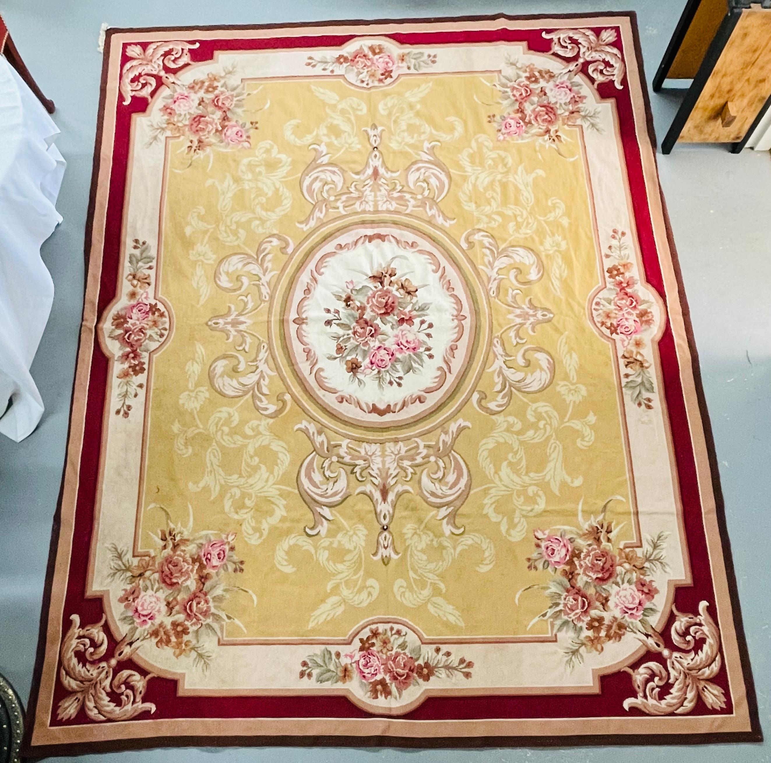 An exquisite vintage handwoven French Victorian Aubusson style floral needlepoint large tapestry, carpet or rug. The tapestry features an intricate floral design in neutral beige, light green, pink and burgundy colors. 
The tapestry shows an oval