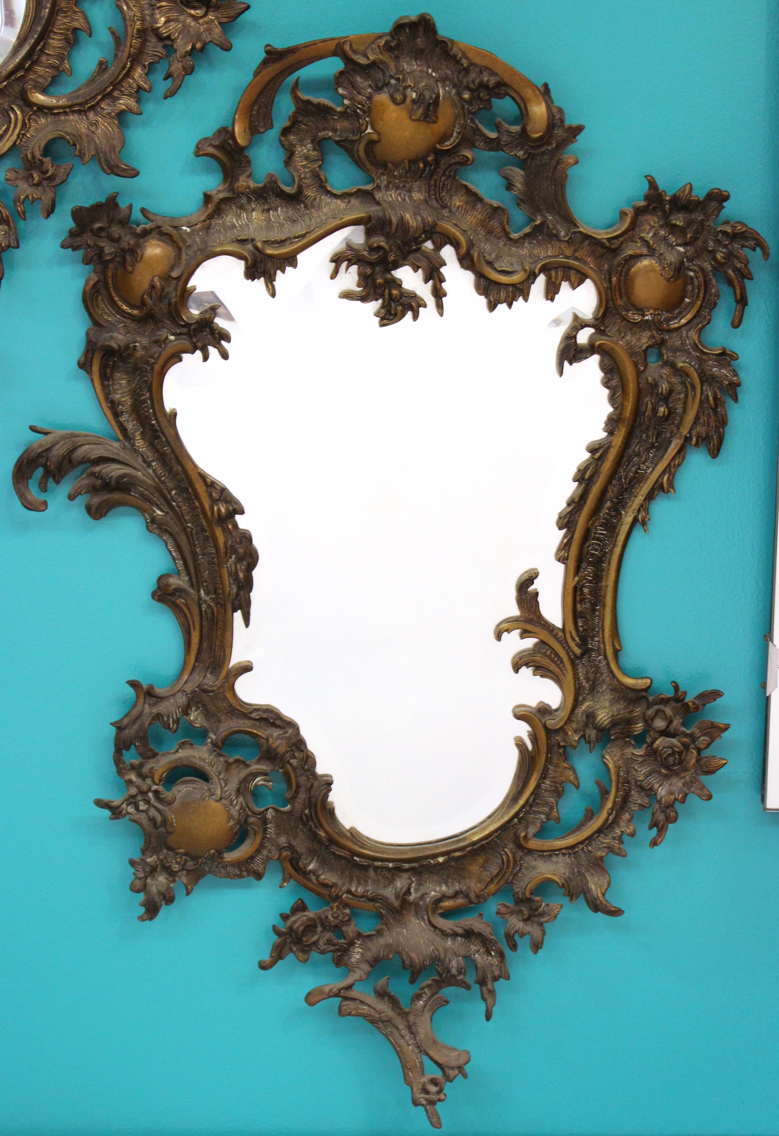Pair of French Victorian beveled mirrors set in elaborately designed high Baroque style bronze frames. The pair was likely made in France during the 1880s and is in great vintage condition with age-appropriate wear and natural patina.