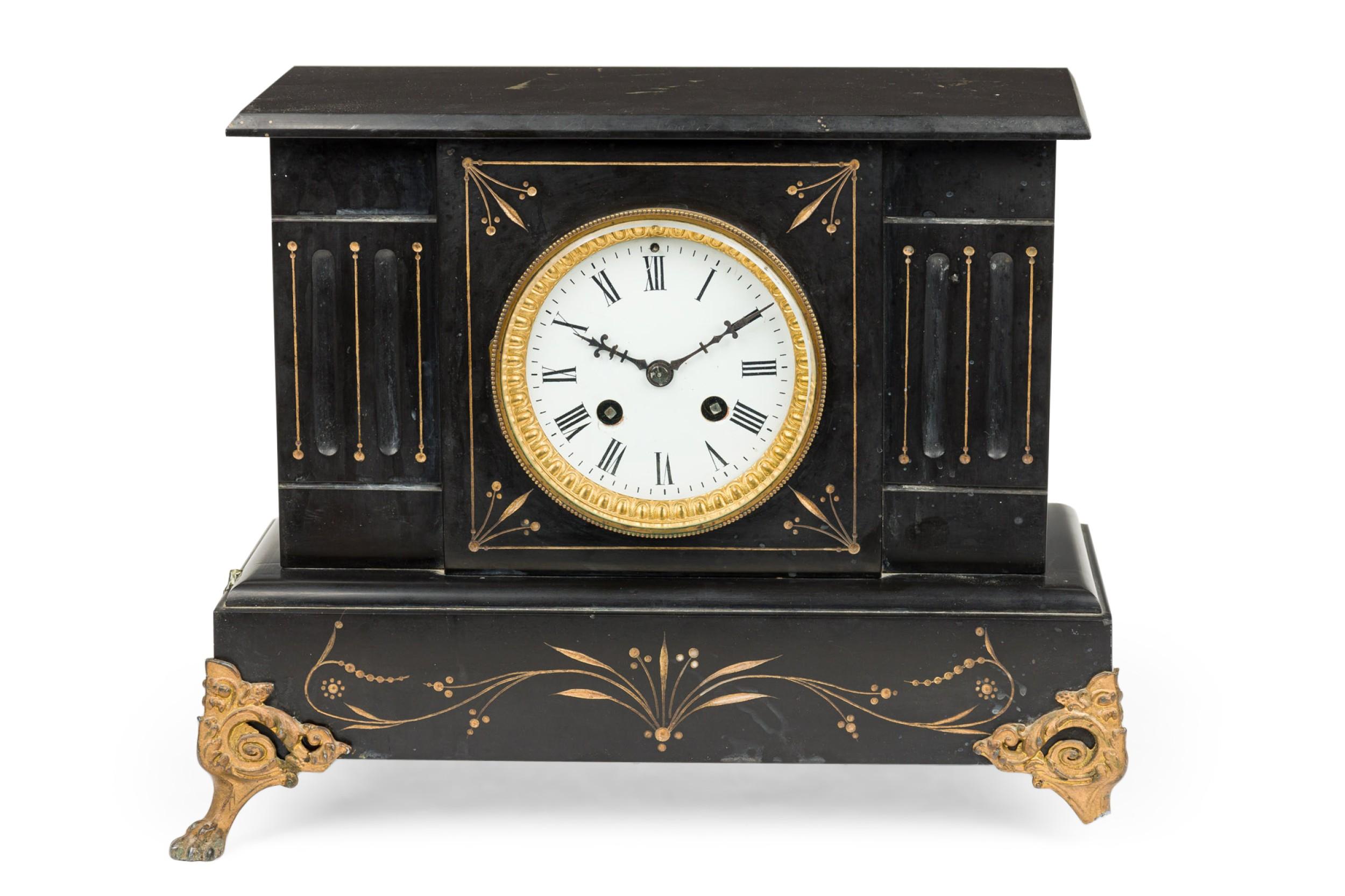 French Victorian black mantle clock having a gilt etched trim with brass dial and white clock face

1 small leg AS IS