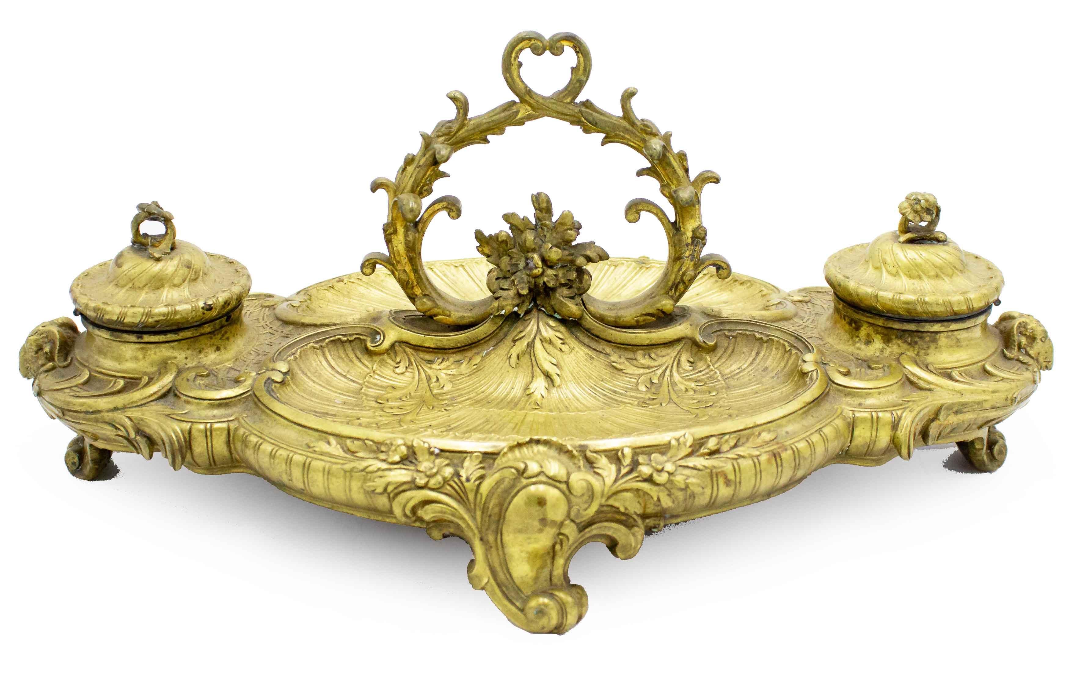 Calamaio francese vittoriano (XIX secolo) in bronzo impreziosito da dettagli floreali, a smerlo e a testa di montone e da una maniglia a voluta centrata con 2 pozzetti.