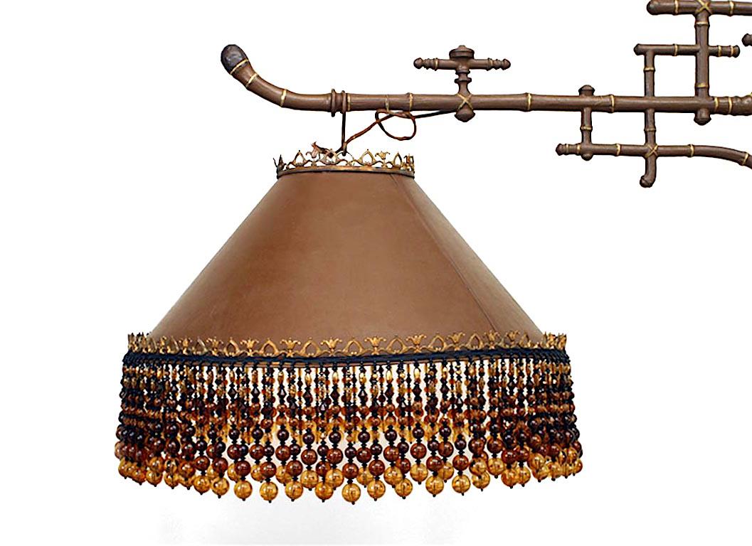 French Victorian brown painted and gold trimmed iron billiard fixture with faux bamboo design and two tole shades with beaded amber glass fringe.
 