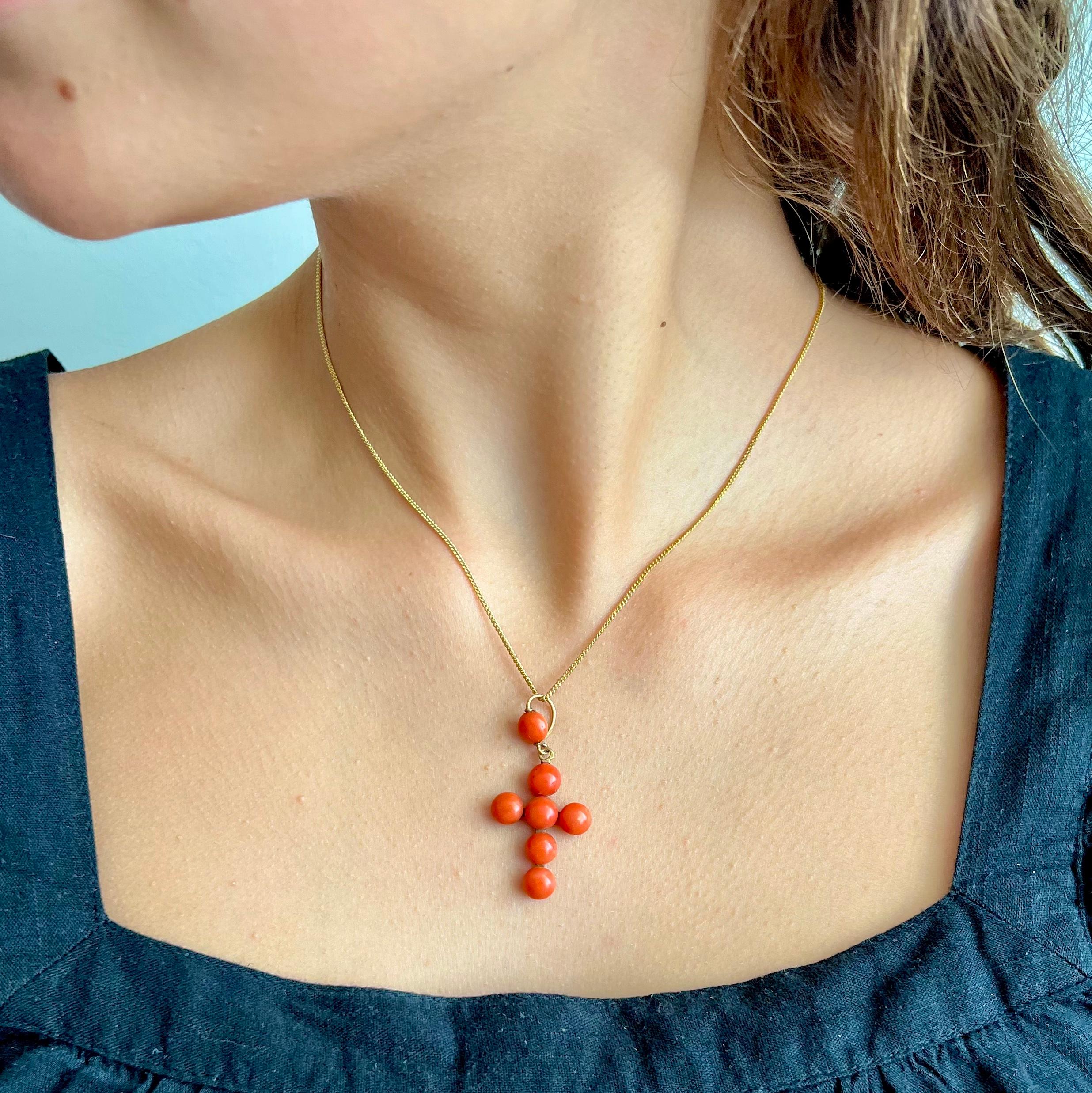 An antique French Victorian cross pendant created with natural coral cabochon bead stones. This lovely antique cross is beautifully decorated with seven red coral cabochons across the front. Of which one coral button set to the bail. The natural