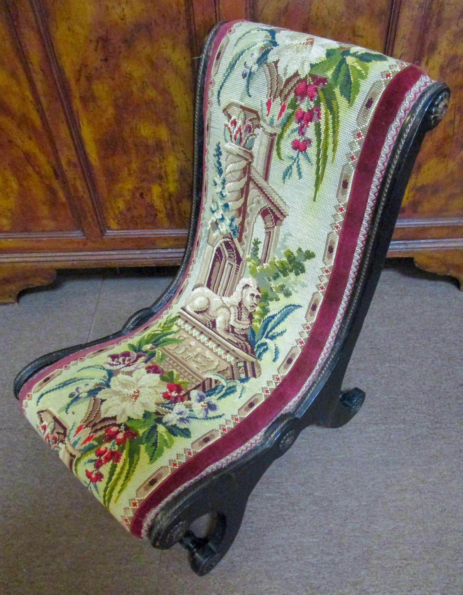 Cette paire très rare de hauts fauteuils Napoléon III prie dieu présente une structure en acajou ébonisé, une tapisserie à l'aiguille détaillée d'origine, des châssis tournés et dix rosettes en laiton sur chaque fauteuil, ainsi qu'une bande en