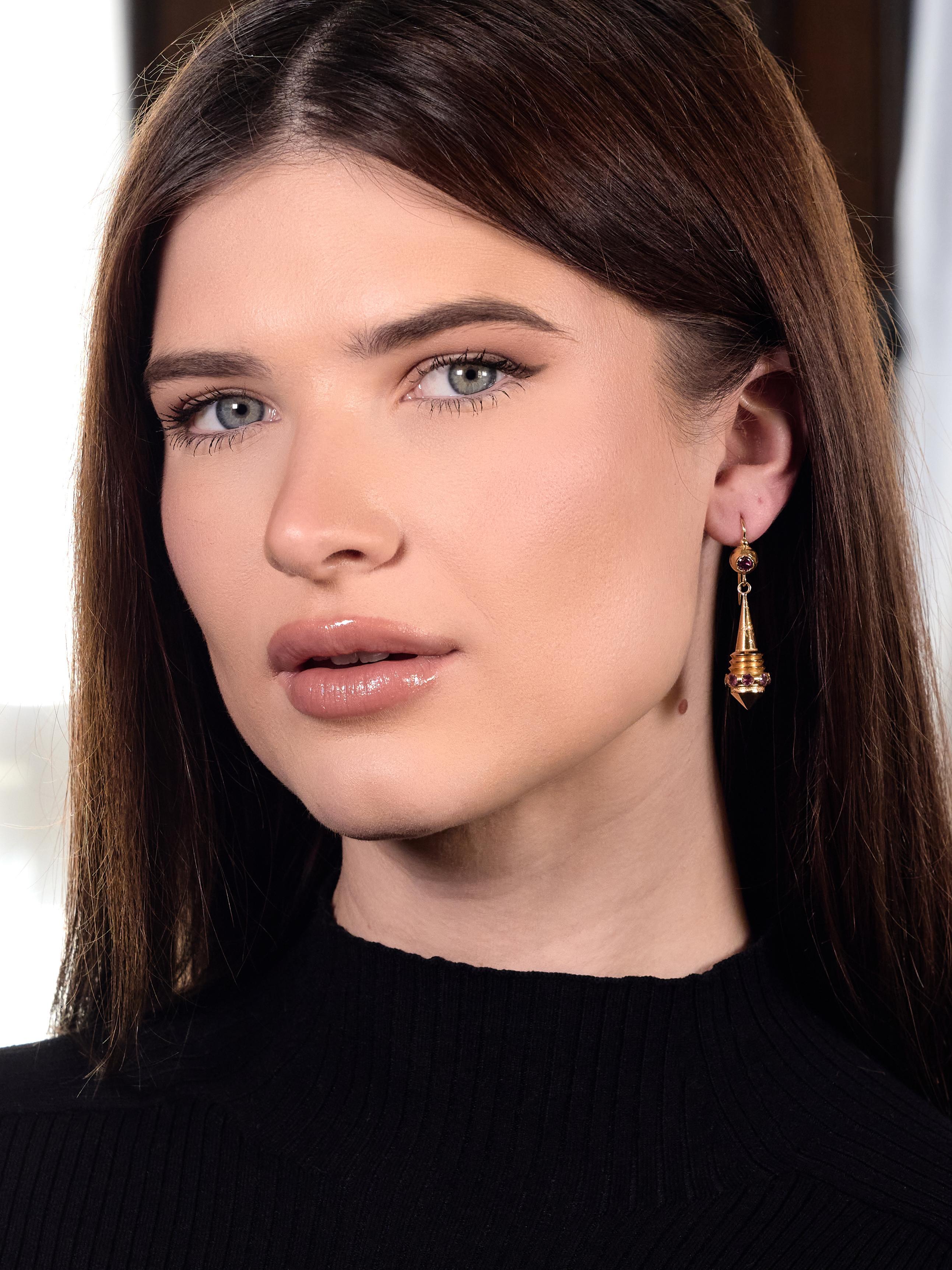 Comprised of domed surmounts suspending spiculum shaped drops
Decorated with grooved form and engraved with scrolling foliates
Featuring round cut tourmalines bezel set in surmount and drops
Ranging in size from 3.0 to 4.0 mm - transparent purplish