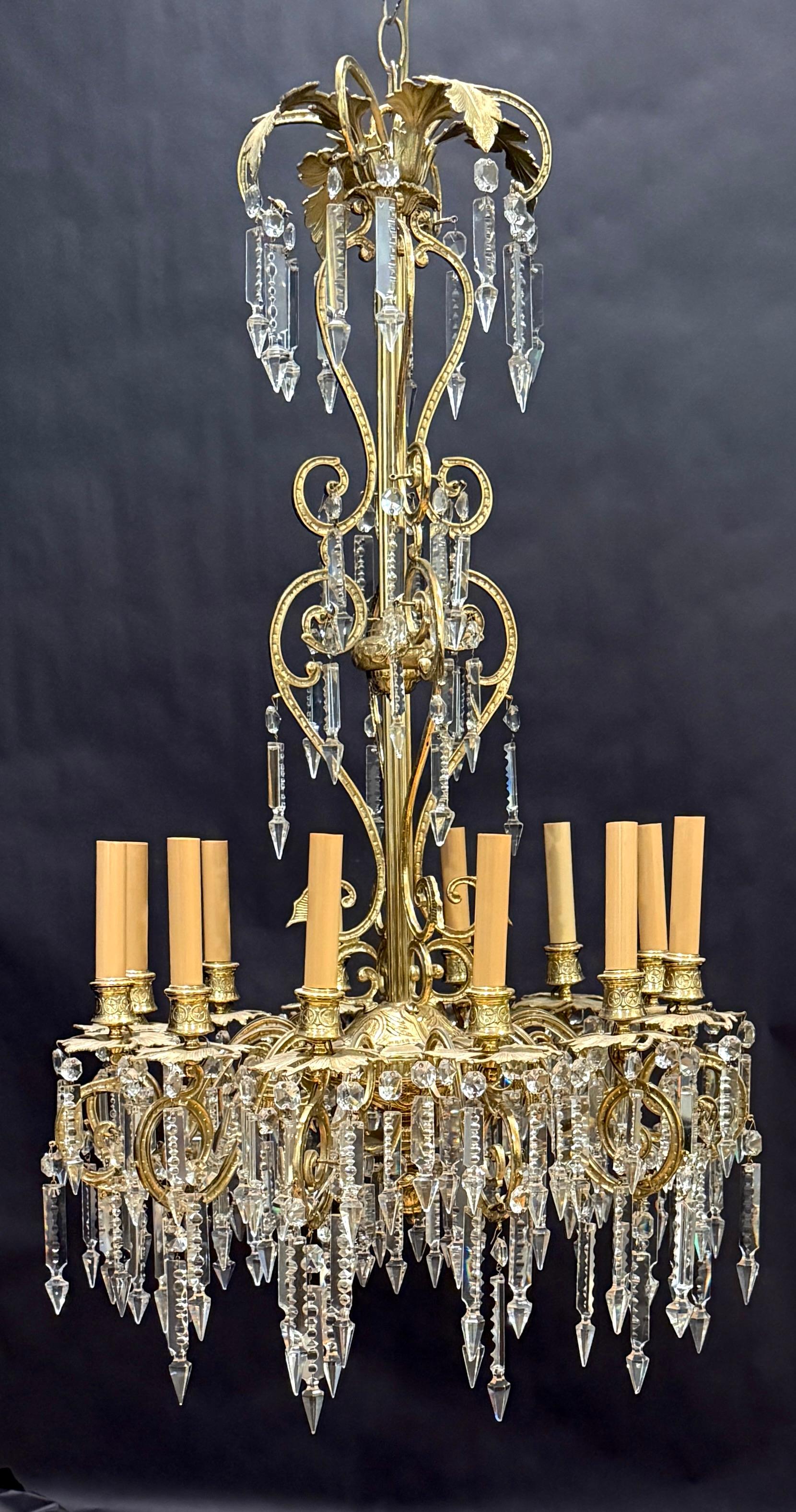 This opulent French Victorian chandelier showcases the lavish detailing and graceful curves characteristic of the Rococo Revival period. Its gilded bronze frame features intricate scrollwork, foliate accents, and finely cast ornamentation that give