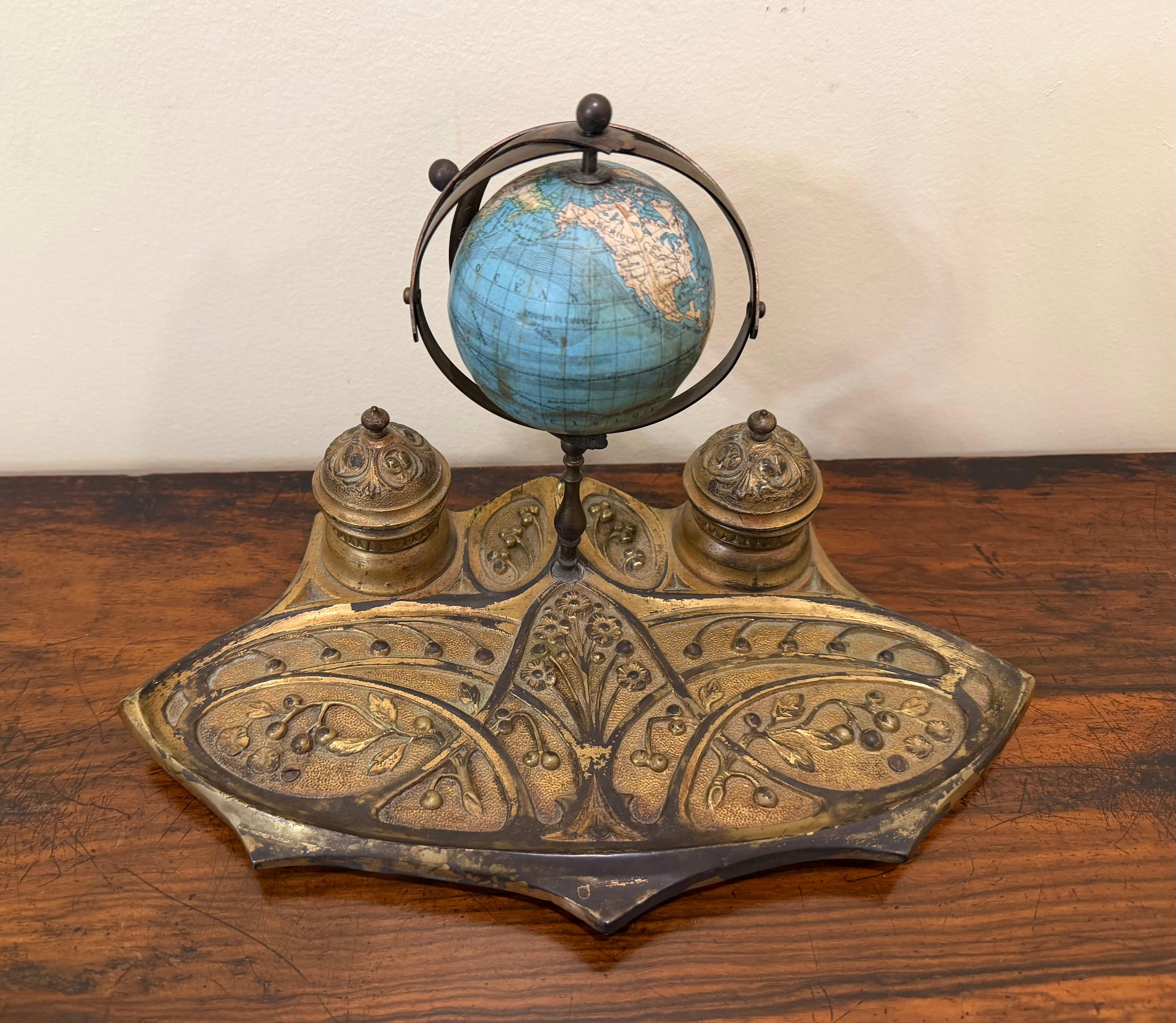 An unusual French gilt brass inkwell in the Art Nouveau style with 2 inkwells centered by a terrestrial 3