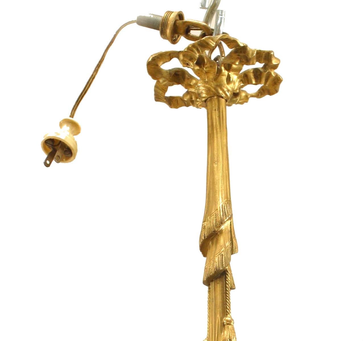 French Victorian gilt bronze chandelier with a drape form center shaft suspending a cupid holding 3 lights having glass flower shades.
